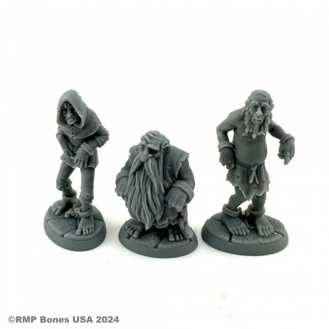 Townsfolk: Prisoners - Three gray resin miniatures of prisoners with ragged clothing and chains, each on round bases.