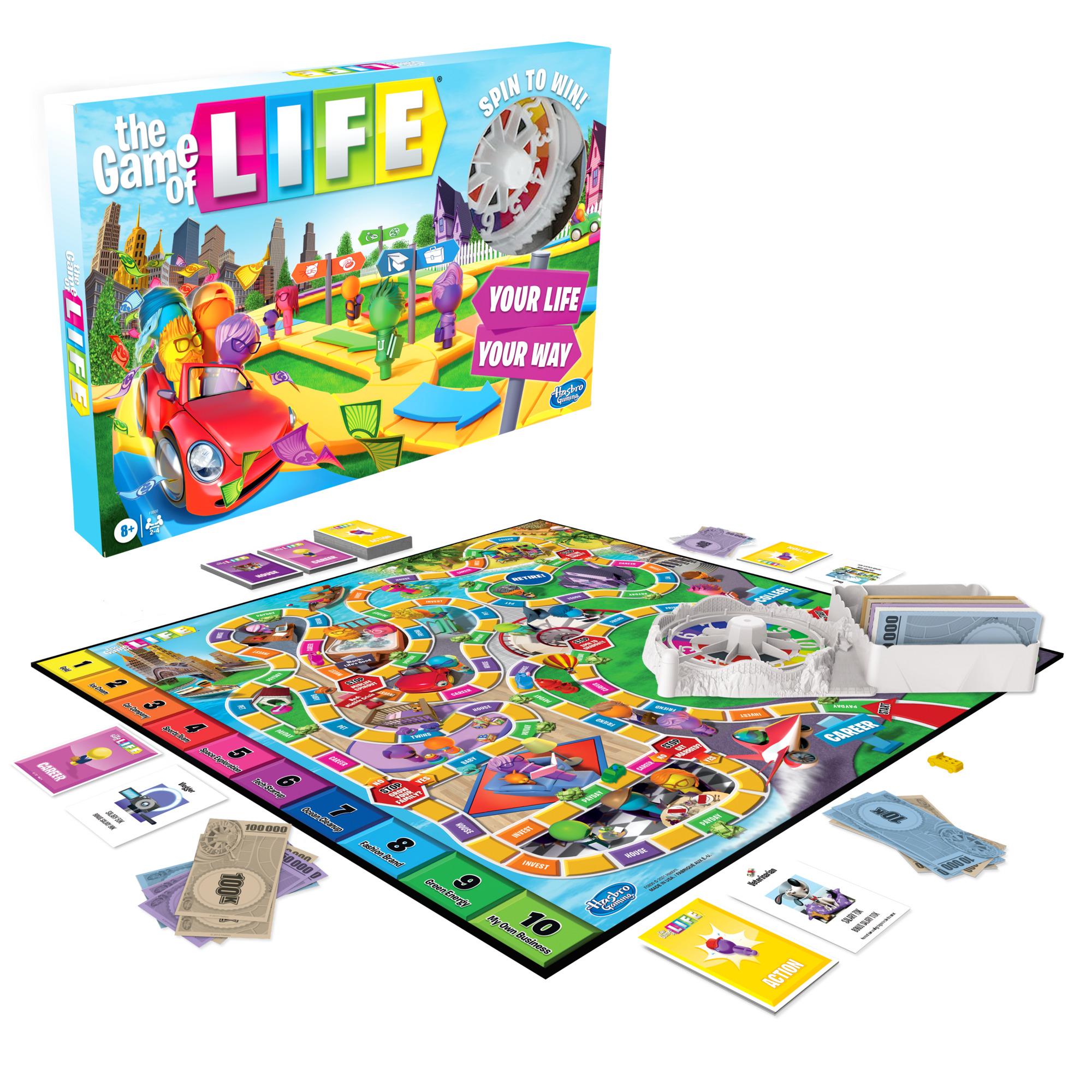 Game of Life (refresh) - Game of Life board game with colorful winding path, plastic spinner, cards, play money, and small car tokens on green surface.