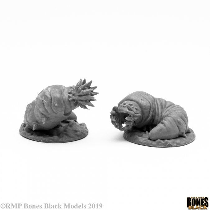 Giant Maggots - Two gray plastic fantasy miniatures of giant maggots with segmented, wrinkled bodies and detailed textured heads on round.