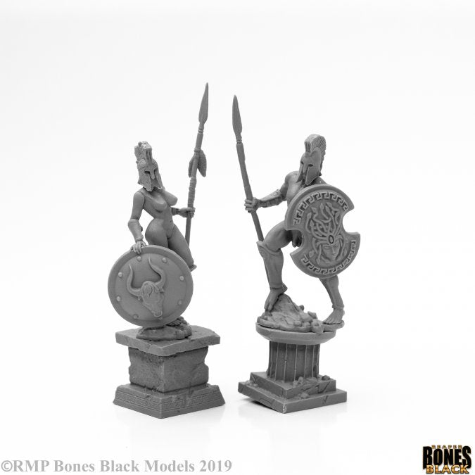 Amazon and Spartan Living Statues (Bronze) - Bronze Amazon warrior statue with spear and shield on square pedestal beside Spartan warrior holding spear and ornate shield .