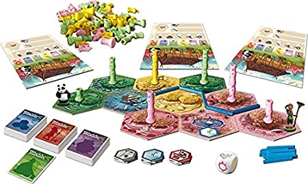 Takenoko - Colorful hexagonal game tiles with bamboo stalks, animal tokens, cards, and a panda figure for a family board game.