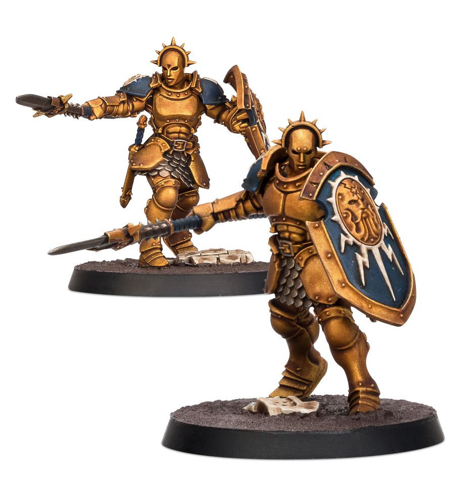 Warhammer Age of Sigmar - Stormcast Eternals - Vindictors and Paint Sets - Two gold-armored Stormcast Eternals miniatures wielding spear and shield, detailed with blue and gold accents on round bases.