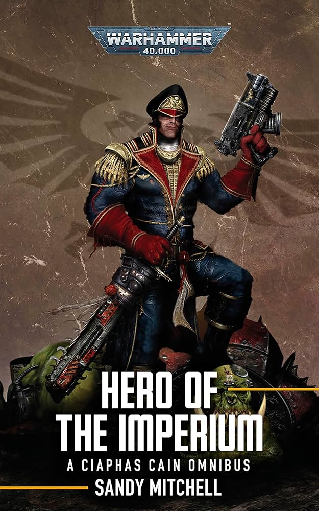 Ciaphas Cain: Hero of the Imperium (Paperback) - Paperback book cover showing a stylized soldier in ornate blue and red armor holding two guns, against a textured brown.