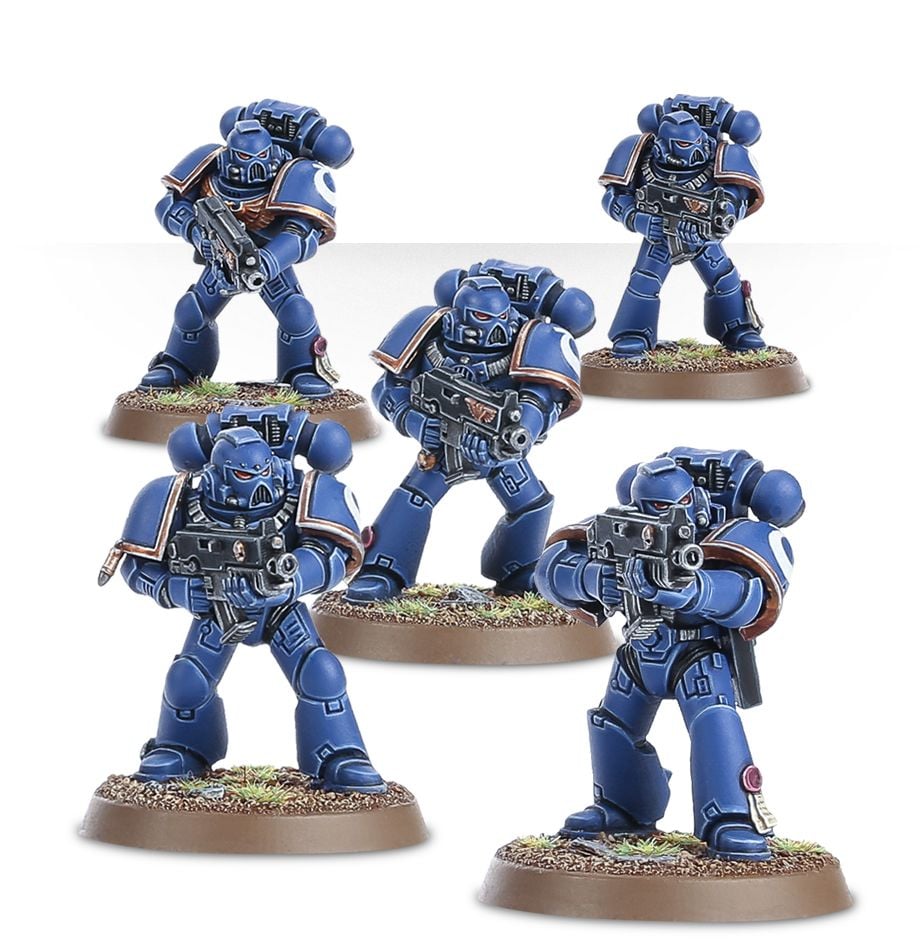 Warhammer 40,000 - Space Marines - Tactical Squad - Five blue-armored Space Marine miniatures in detailed tactical poses, each holding futuristic rifles, standing on textured.