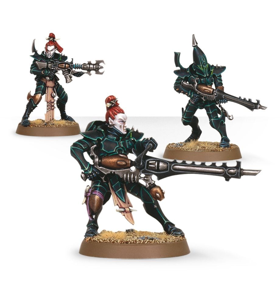 Warhammer 40,000 - Drukhari - Kabalite Warriors - Three painted Drukhari Kabalite Warrior miniatures with dark green armor, red hair, and futuristic rifles, posed on sandy.