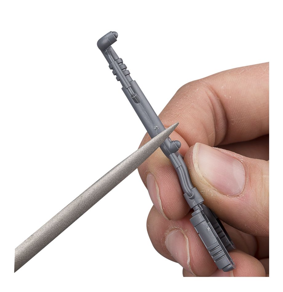 Citadel Tools - File Set - Hand filing a small gray plastic miniature weapon using a metal needle file from the Citadel Tools set.