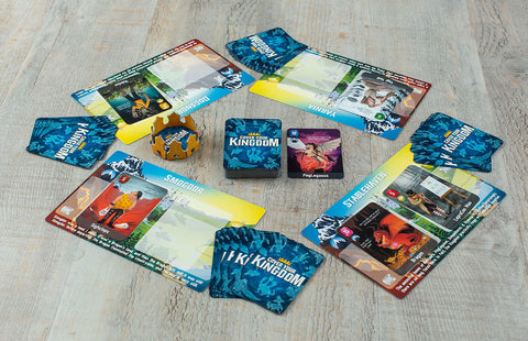 Cover Your Kingdom - Cover Your Kingdom card game with colorful character cards and rule sheets on wooden surface.