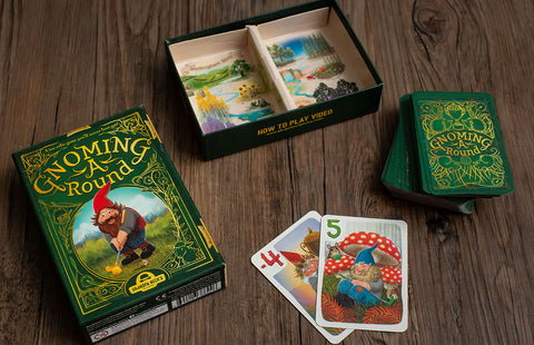 Gnoming A Round - Gnoming A Round card game box with green and gold design, wooden playing cards featuring gnome illustrations and nature.