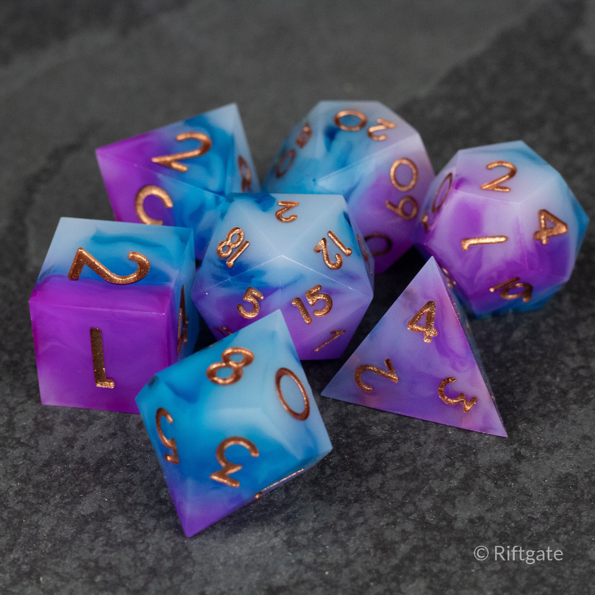 Arcane Tempest Dice Set - Seven sharp-edged polyhedral dice in swirling purple and blue with copper numbers.