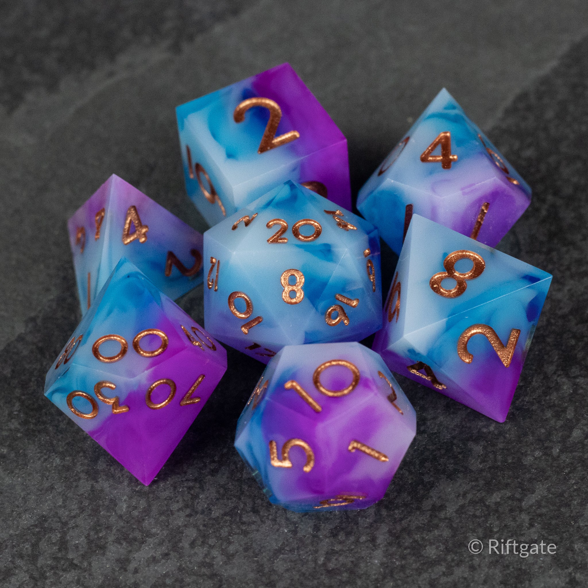 Arcane Tempest Dice Set - Seven polyhedral dice with a swirling purple and blue marble pattern and gold numbers.