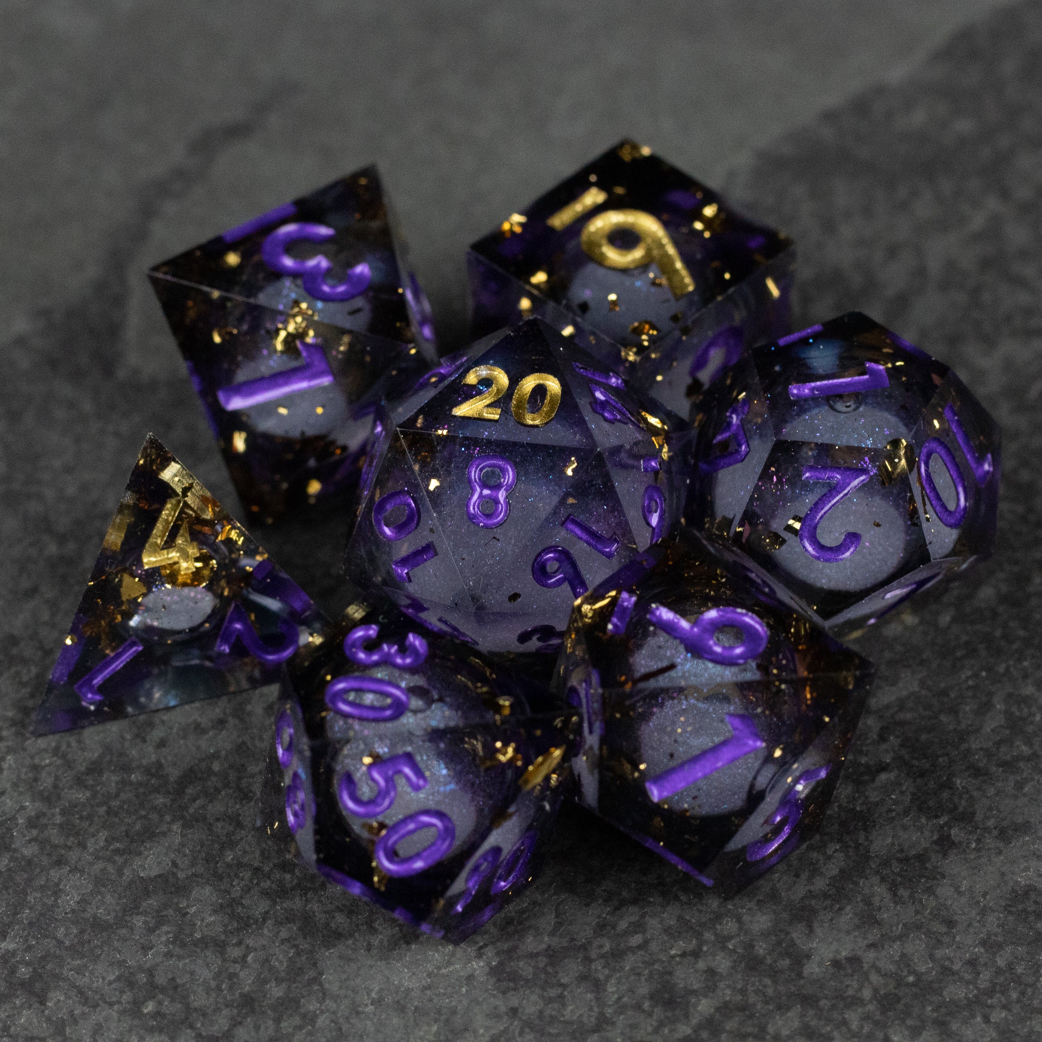 Witching Hour Liquid Core Dice - Set of seven sharp-edged translucent black dice with purple numbers and gold liquid core accents.