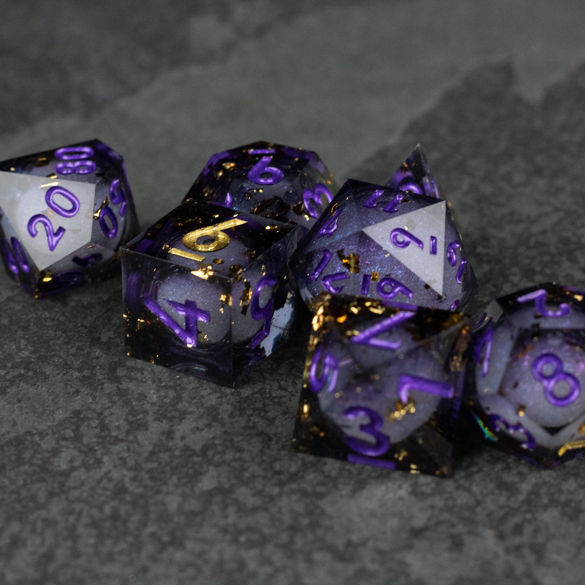 Witching Hour Liquid Core Dice - Set of sharp-edged polyhedral dice with translucent purple liquid core and metallic gold and purple numbering.