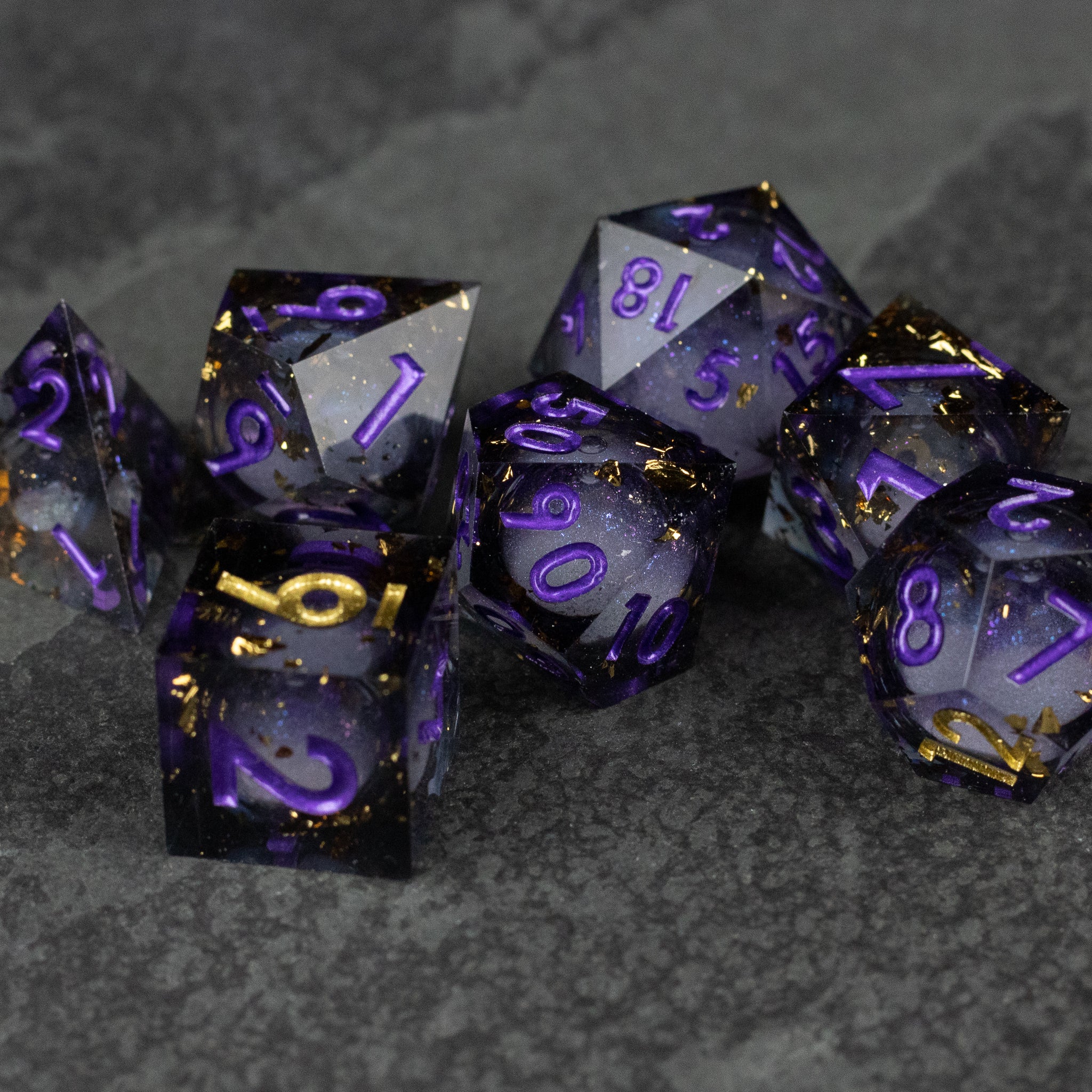 Witching Hour Liquid Core Dice - Set of seven sharp-edged black dice with translucent purple liquid core and purple numbers.