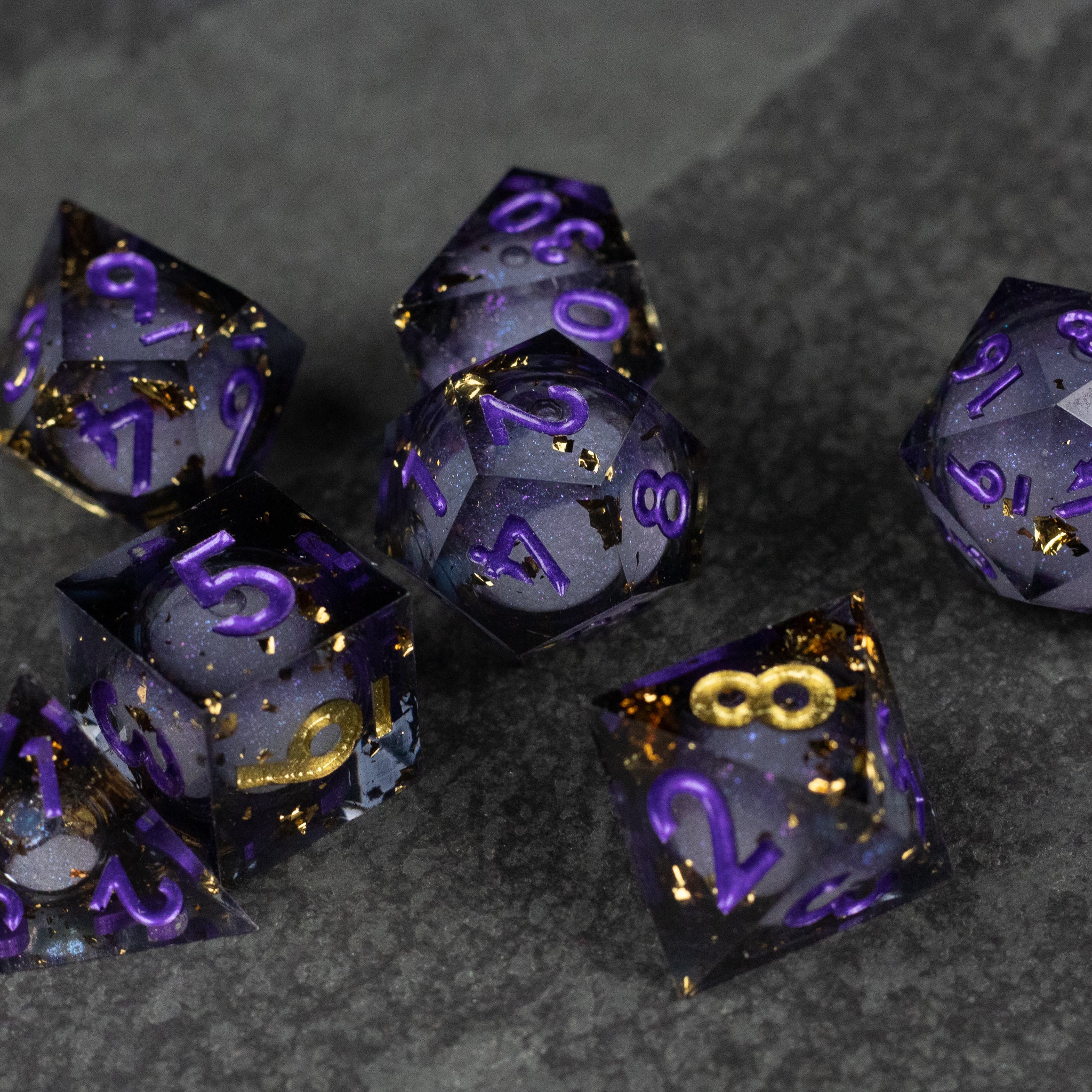 Witching Hour Liquid Core Dice - Set of seven sharp-edged polyhedral dice with translucent black liquid core and purple metallic numbers.