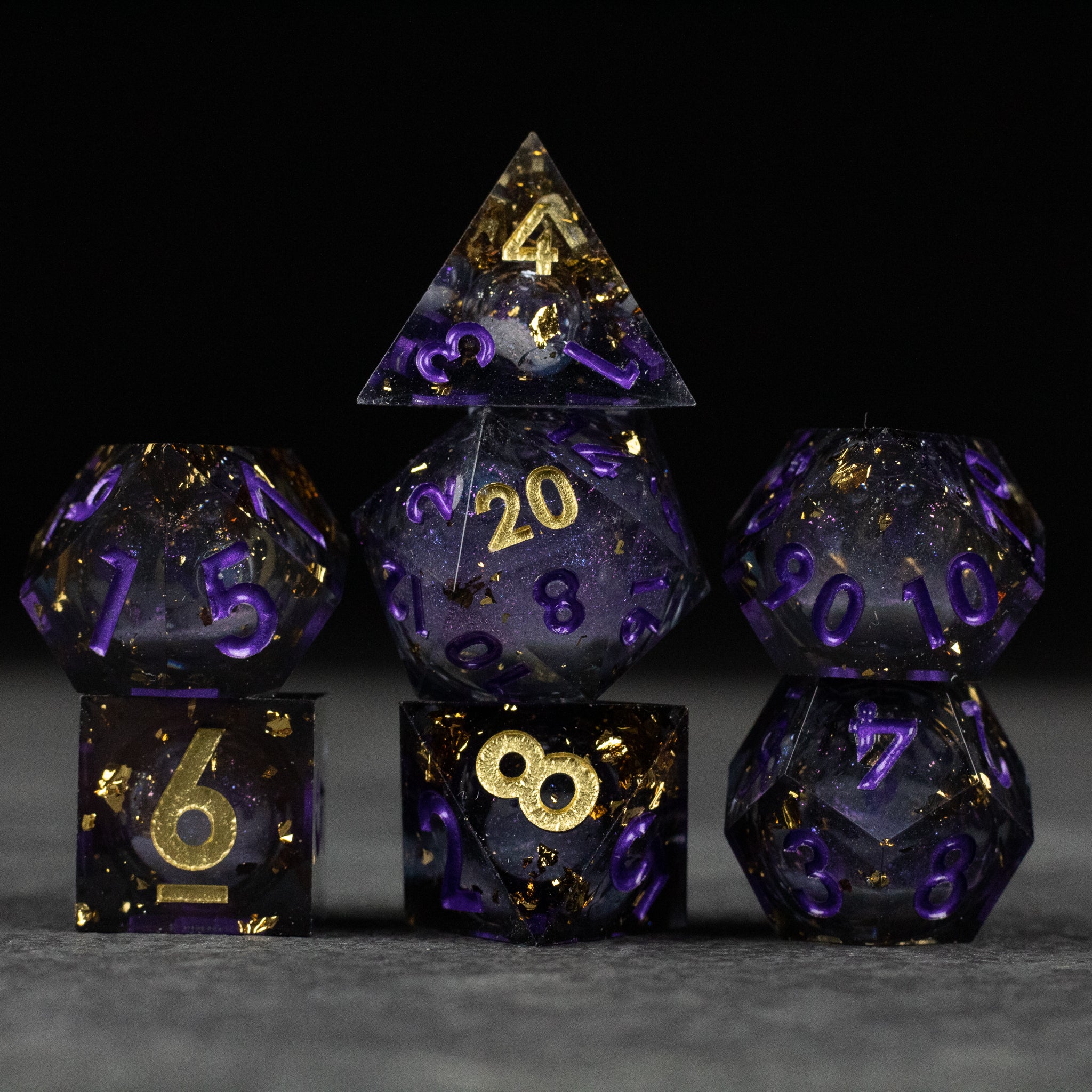 Witching Hour Liquid Core Dice - Set of seven sharp-edged polyhedral dice with deep purple translucent bodies, gold liquid core, and gold numbering.