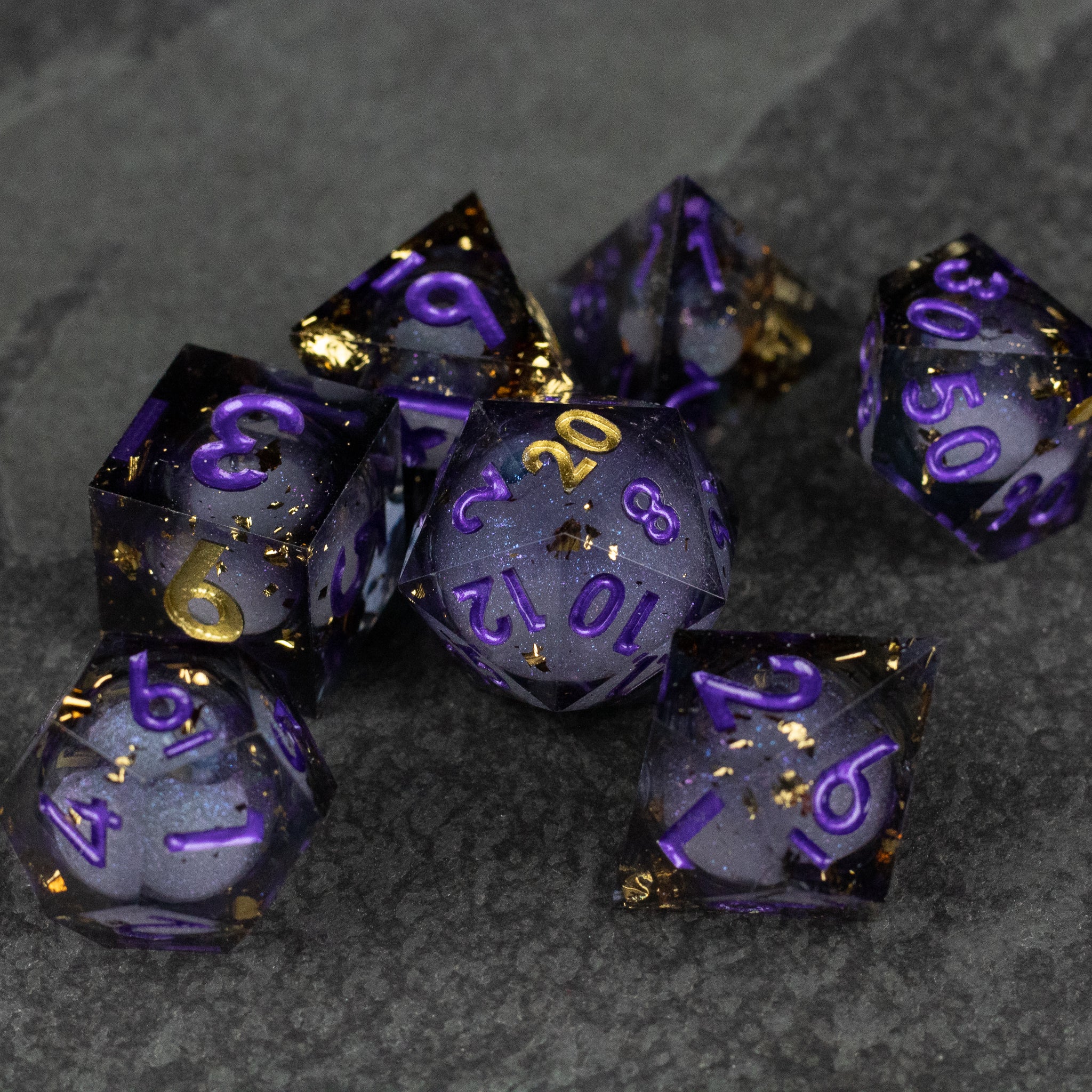 Witching Hour Liquid Core Dice - Sharp-edged translucent dice with purple liquid core, gold flecks, and gold numbering.