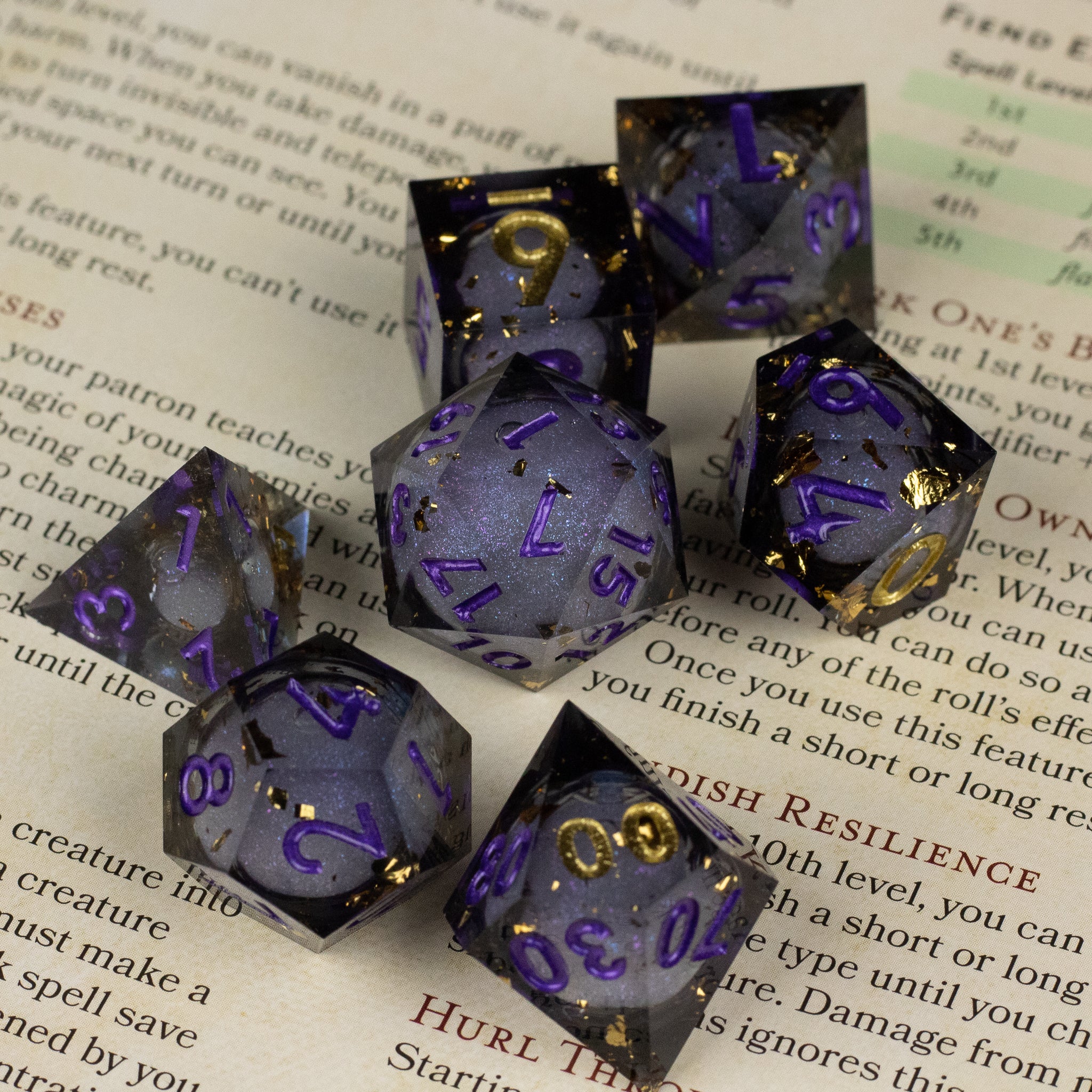 Witching Hour Liquid Core Dice - Set of seven sharp-edged dice with translucent dark purple liquid core and gold or purple numbering.