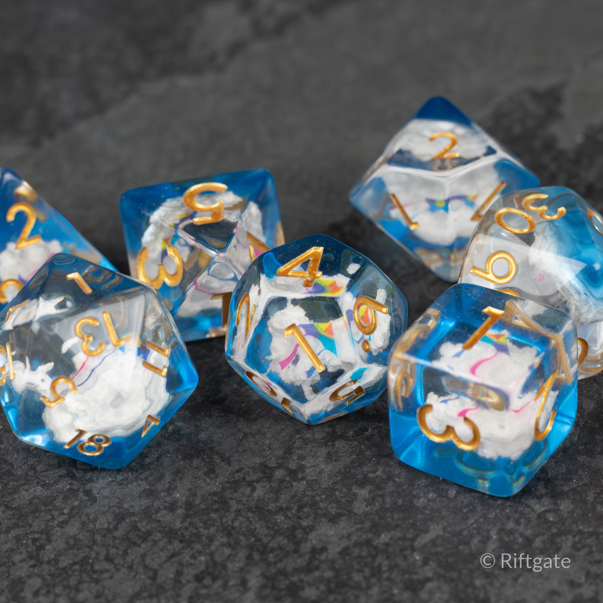 Clouds & Kites Dice - Set of clear blue and white marbled polyhedral dice with gold numbers and cloud and kite inclusions inside.