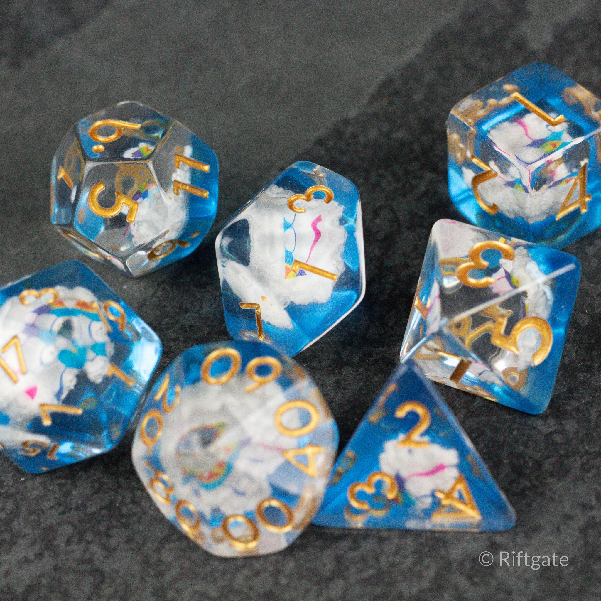 Clouds & Kites Dice - Transparent blue and white marbled polyhedral dice set with gold, pink, and blue numbers and unique cloud and kite inclusions.