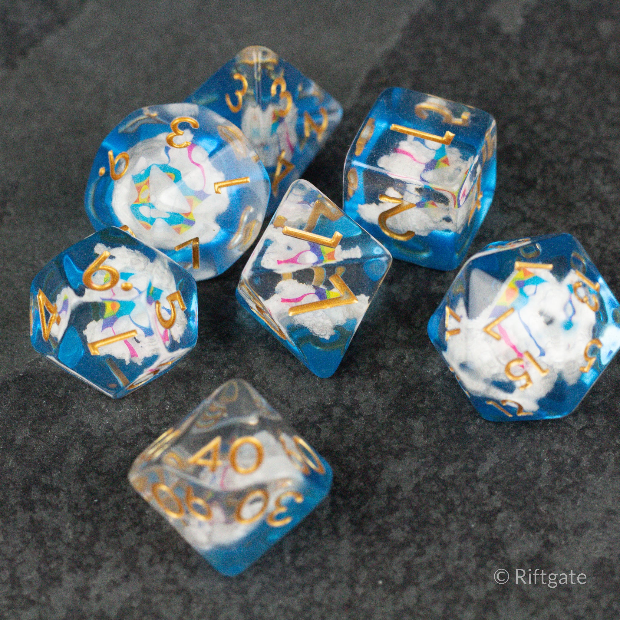 Clouds & Kites Dice - Set of seven translucent blue polyhedral dice with clouds and colorful kite designs, gold numbering.