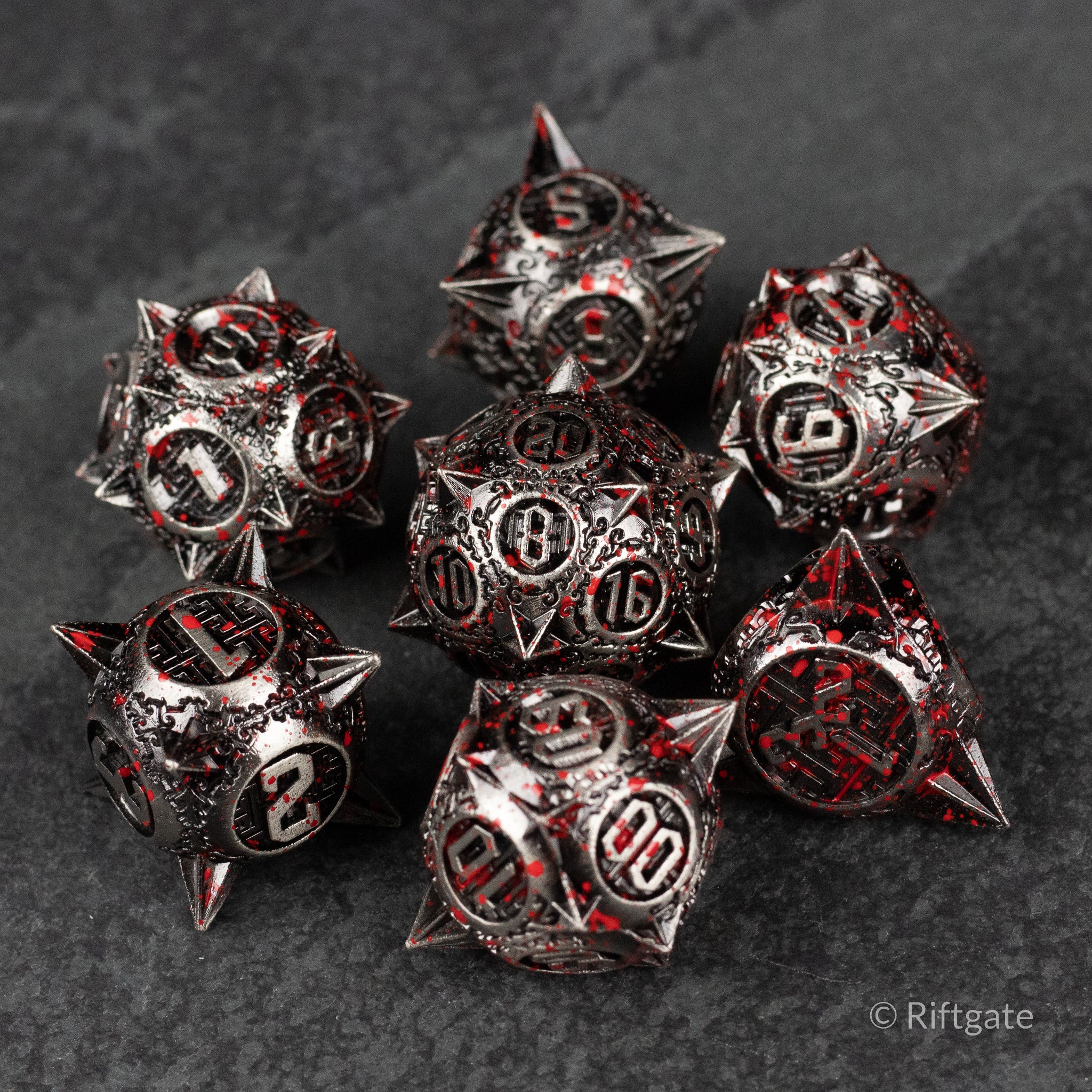 Bloody Morning Star Metal Dice Set - Set of seven spiked metal dice with black and red splatter, white numbers on dark background.