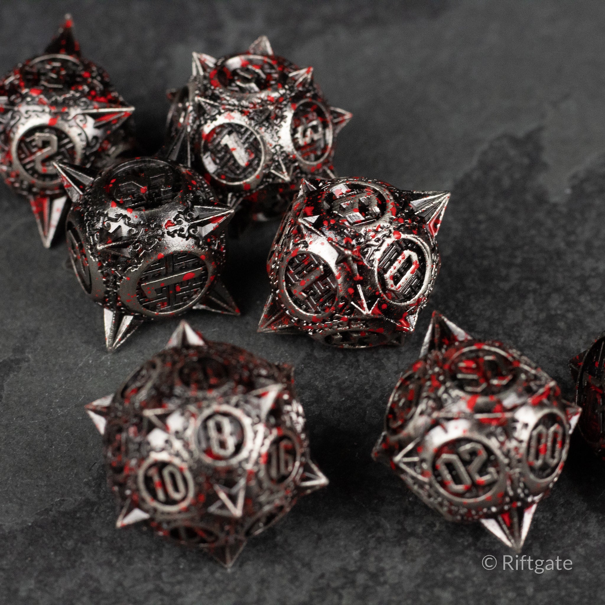 Bloody Morning Star Metal Dice Set - Set of six spiked metal dice with black and red blood-splatter finish and white numbers.