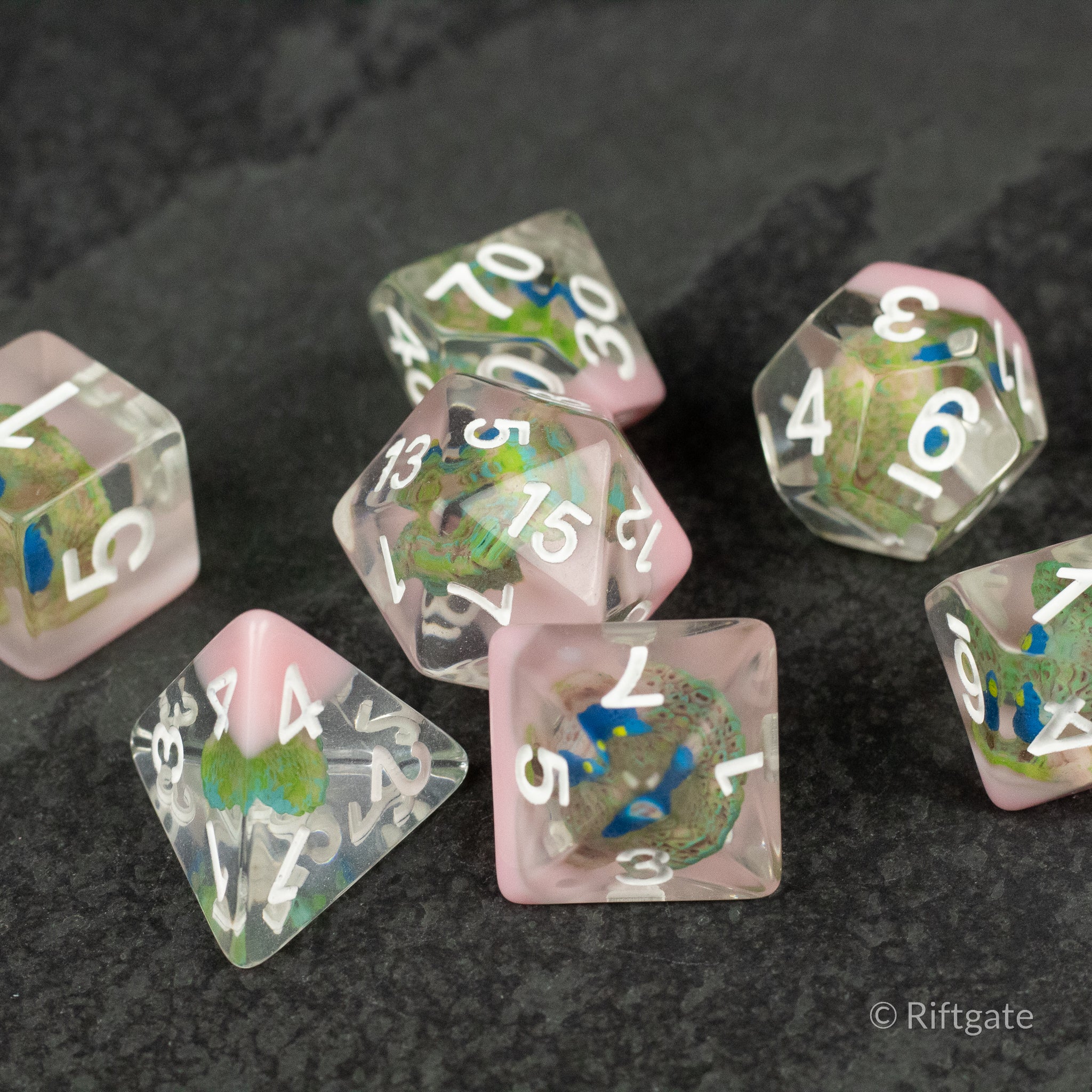 Peacock Dice Set - Set of seven translucent polyhedral dice with embedded peacock feather designs and colored numbering.