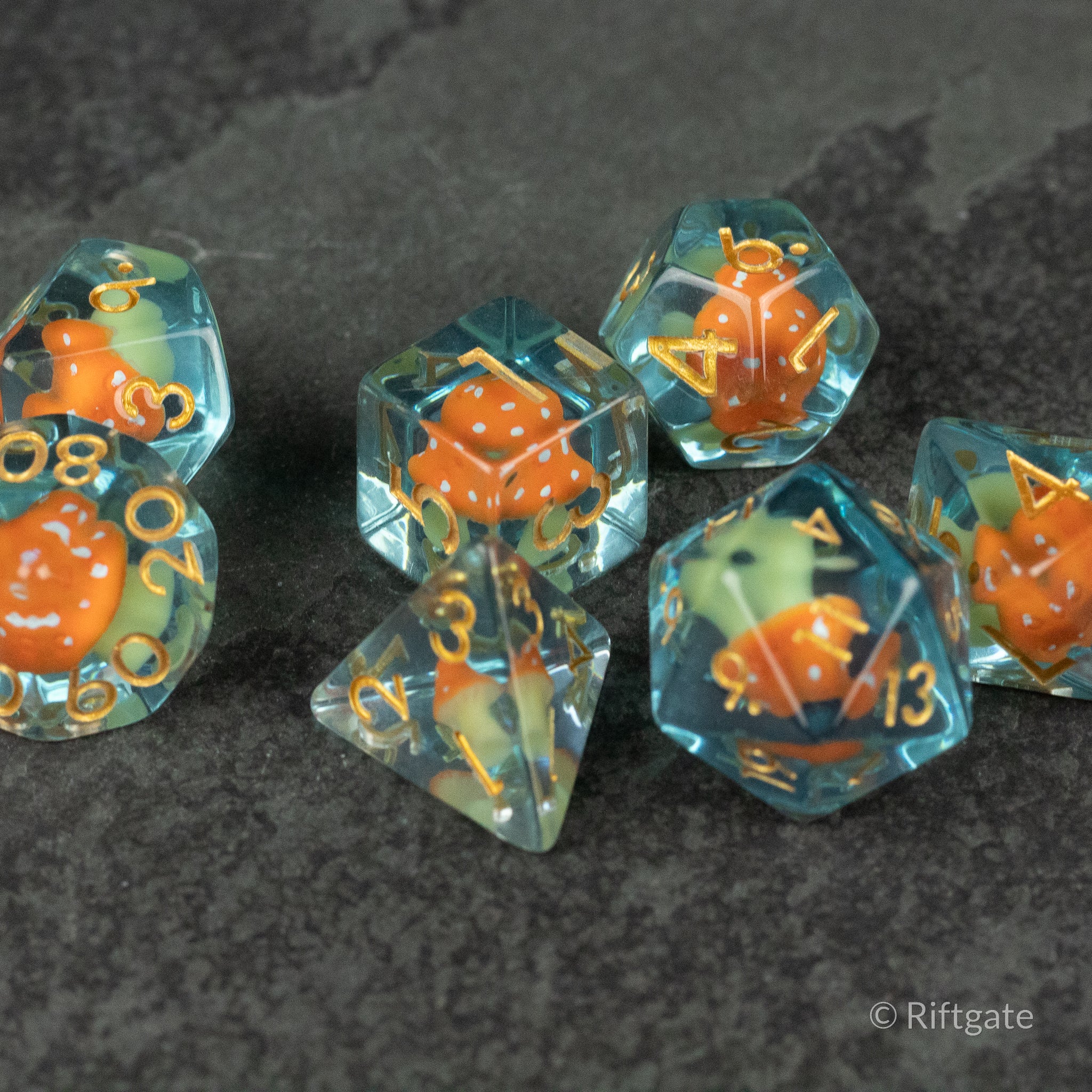 Orange + Blue Resin Mushroom Dice Set - Set of seven translucent resin dice with orange mushroom and blue swirl inclusions, gold numbering.