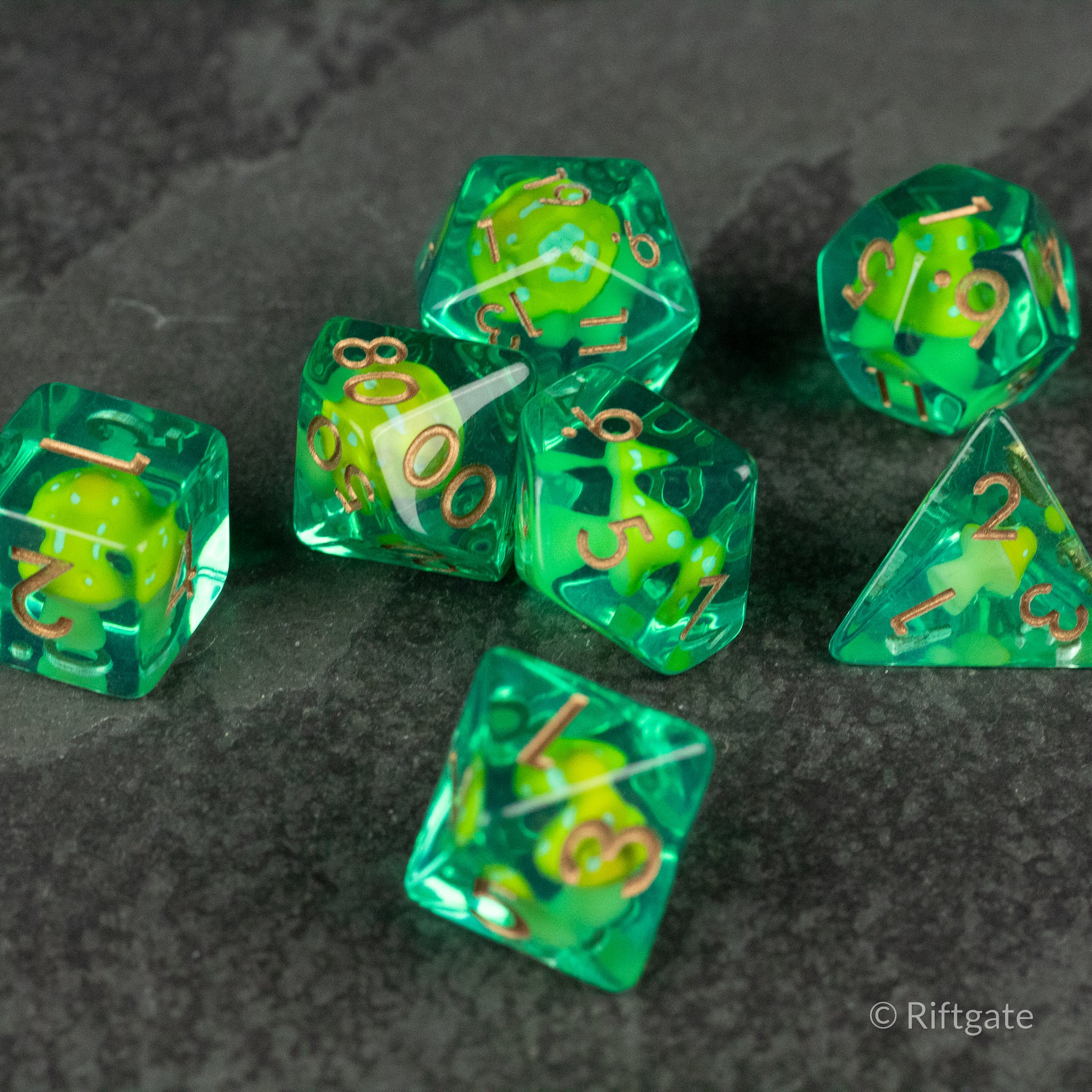 Yellow + Green Resin Mushroom Dice Set - Green and yellow resin polyhedral dice set with embedded mushroom shapes and gold numbering.