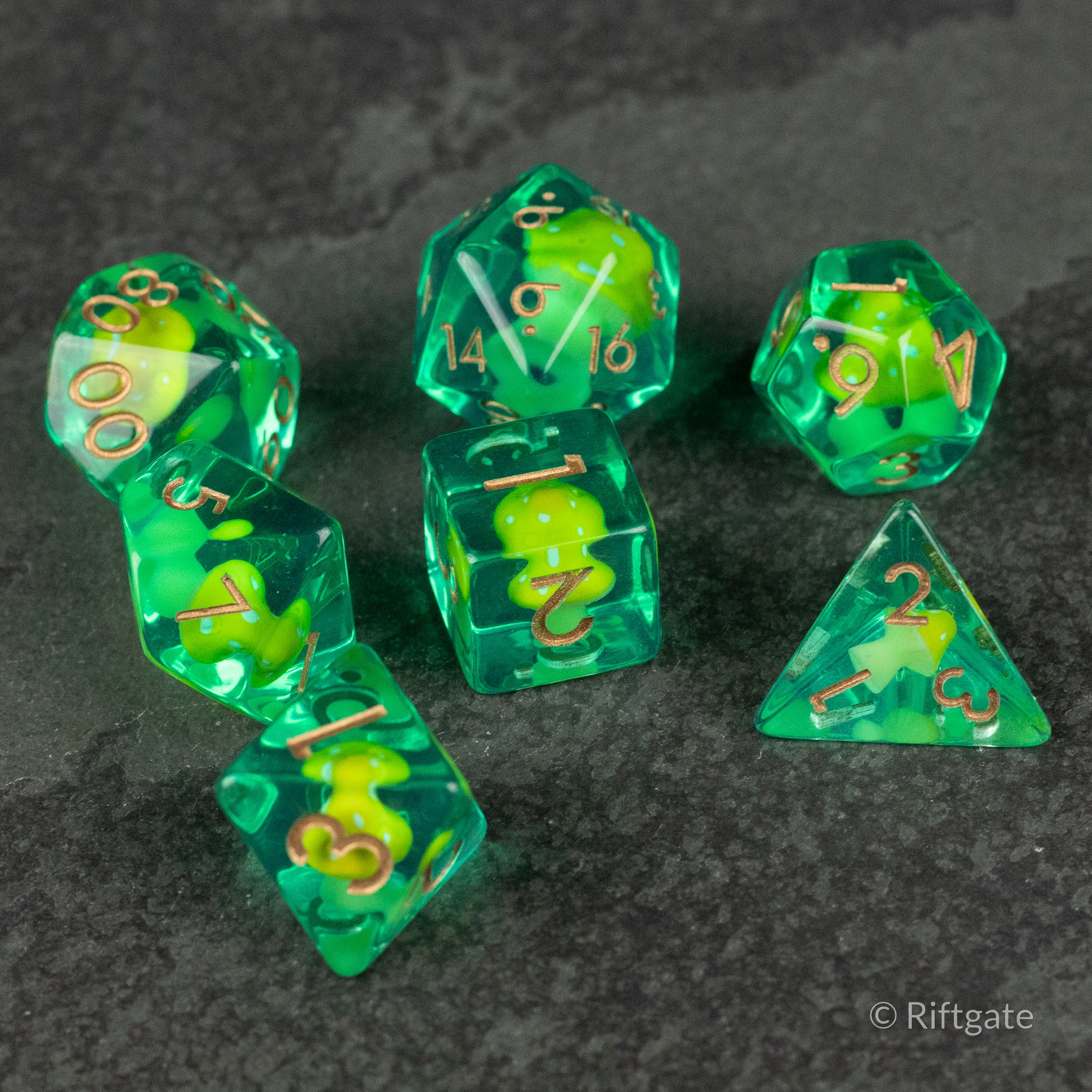 Yellow + Green Resin Mushroom Dice Set - Translucent green resin polyhedral dice with embedded yellow and green mushroom shapes and gold numbering.