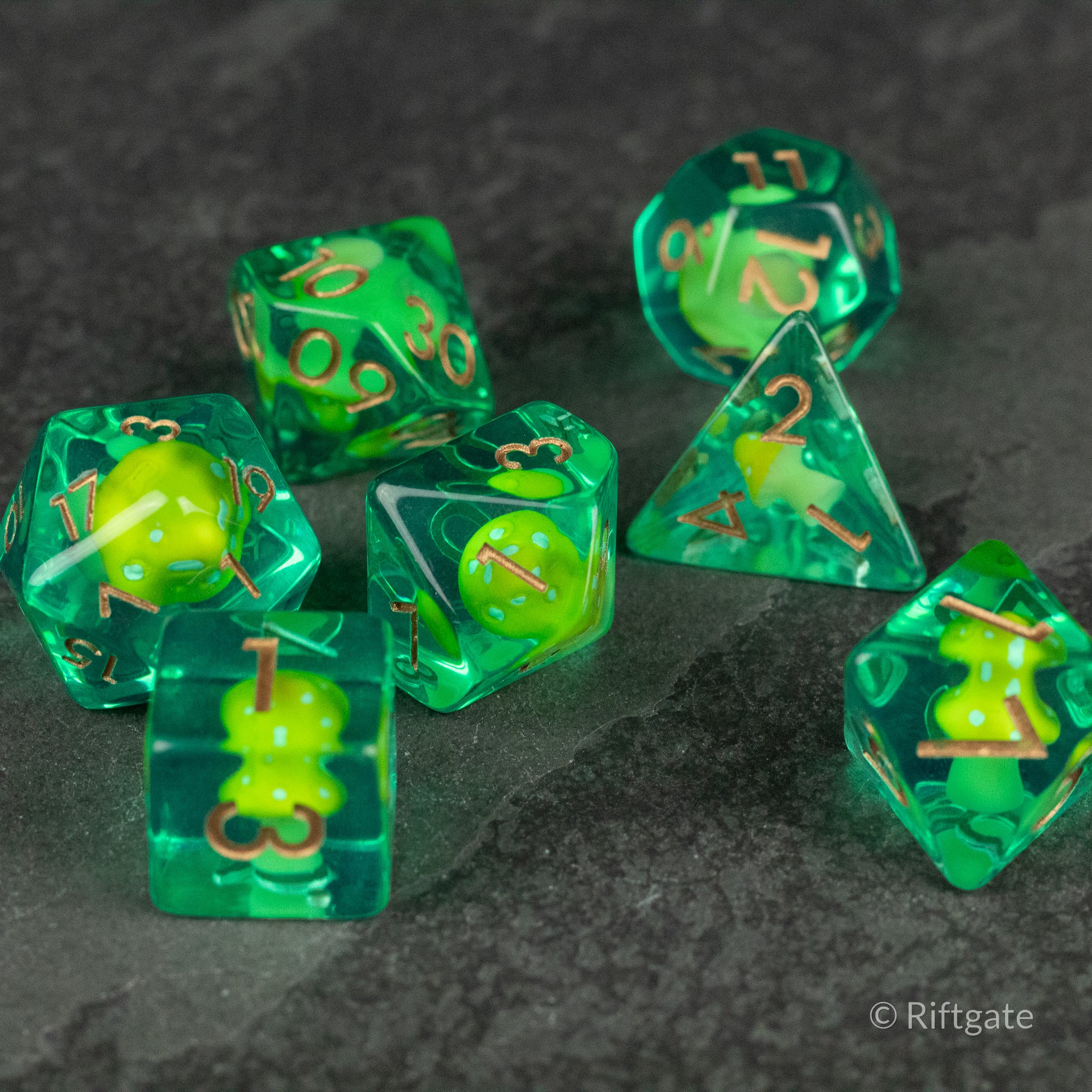Yellow + Green Resin Mushroom Dice Set - Translucent green resin dice set with yellow mushroom inclusions and gold numbering, various polyhedral shapes.