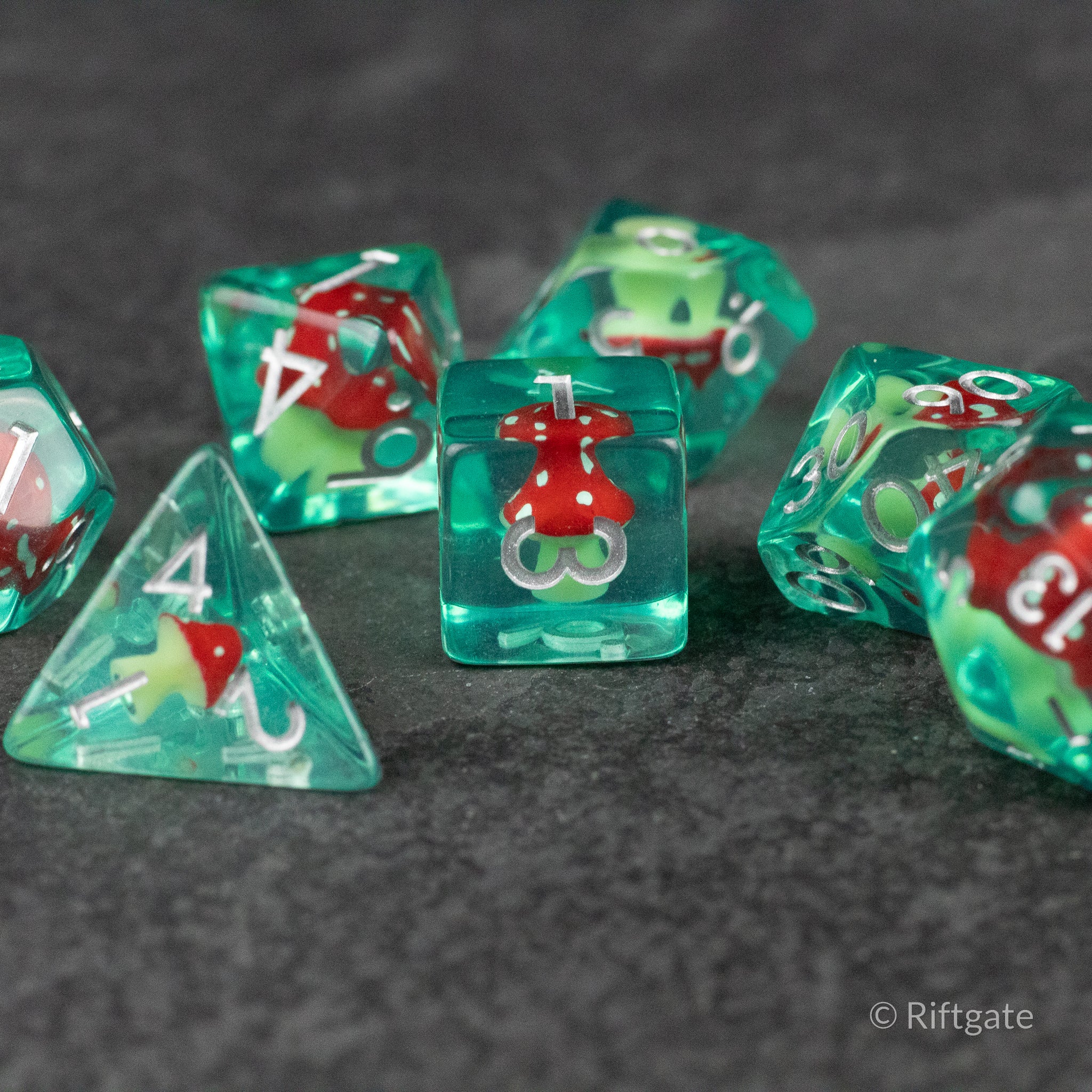Red + Green Resin Mushroom Dice Set - Translucent green resin dice with red and white mushroom inclusions and white numbering.