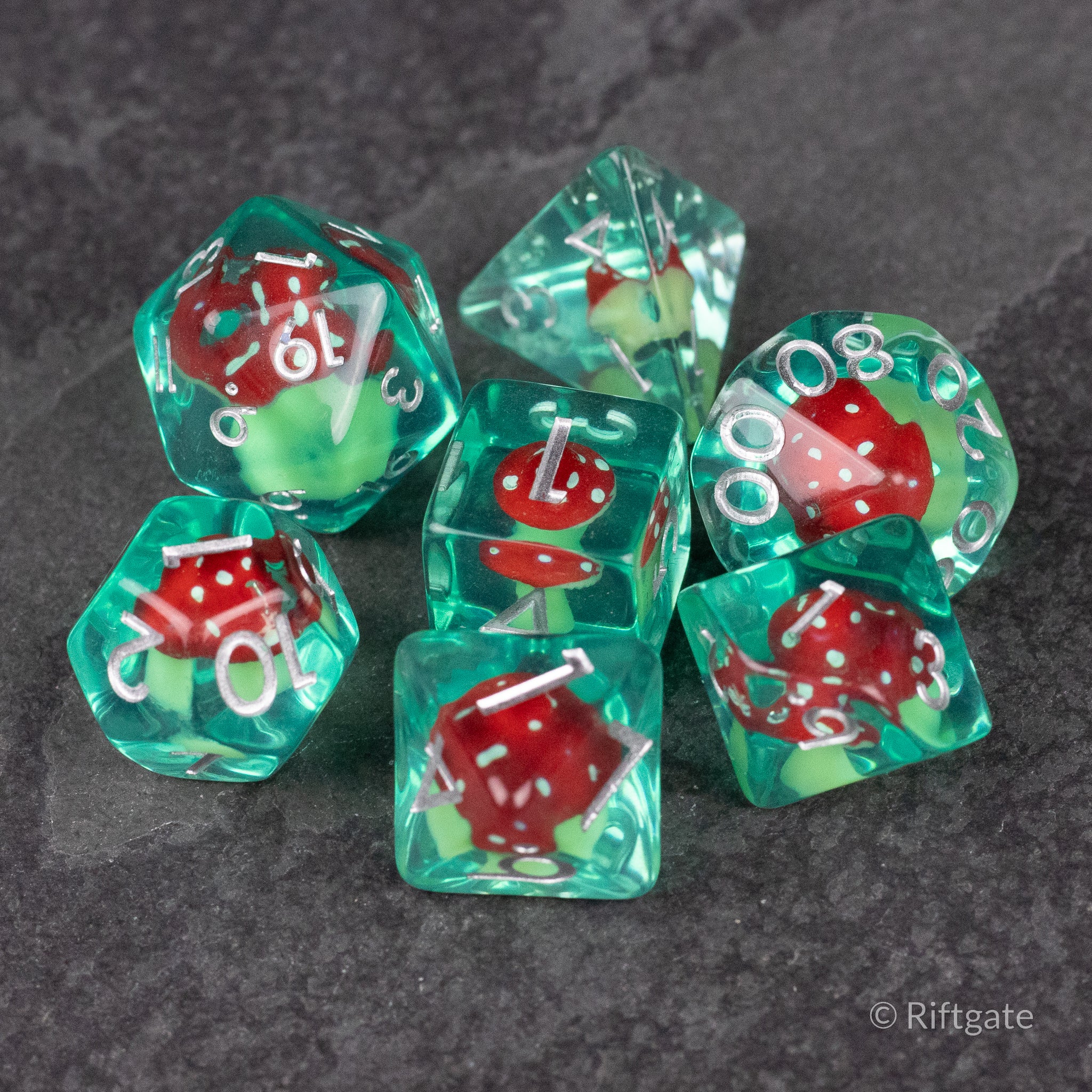 Red + Green Resin Mushroom Dice Set - Transparent green resin dice set with red and white mushroom inclusions, various polyhedral shapes.