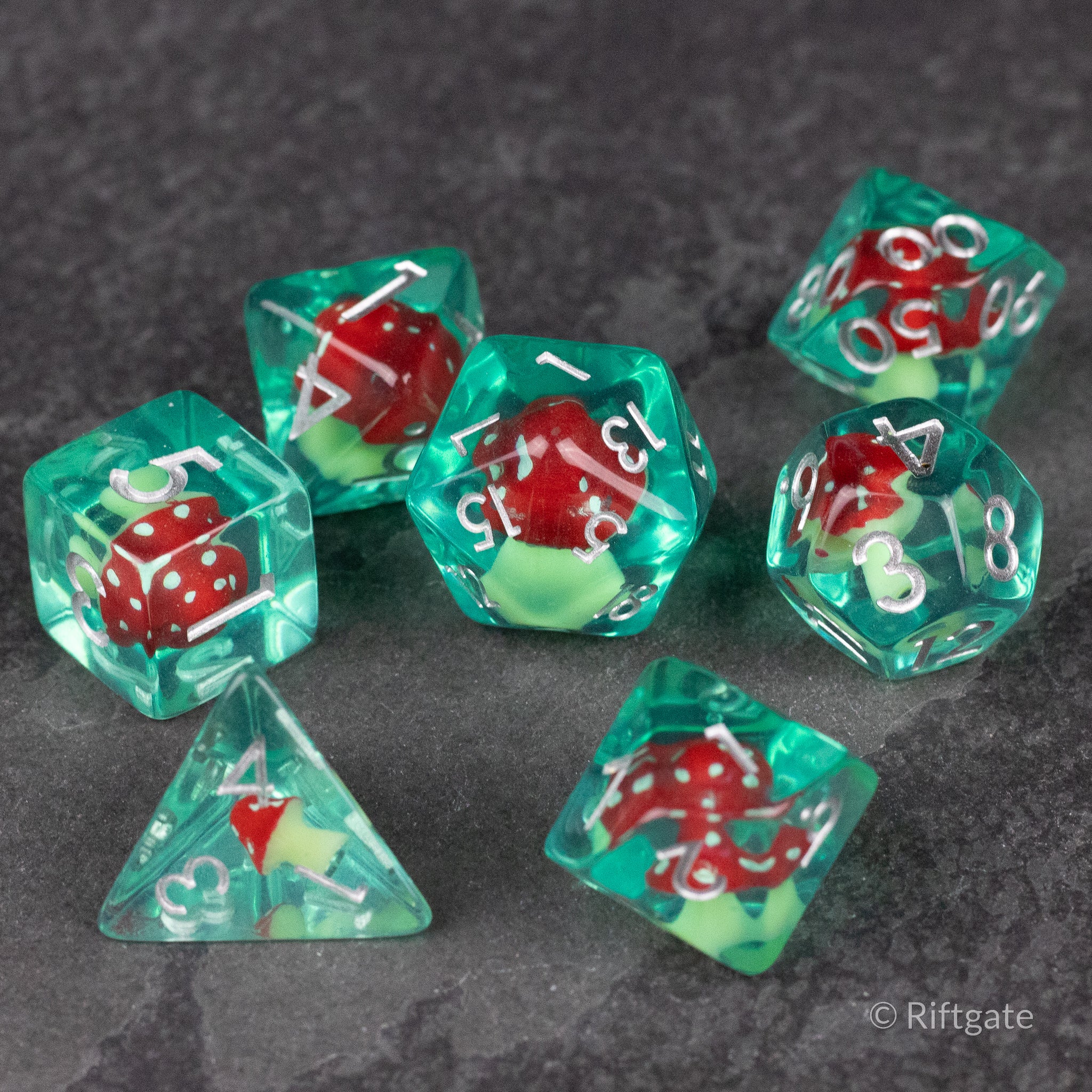 Red + Green Resin Mushroom Dice Set - Translucent green resin dice set with embedded red mushrooms and white numbers, various polyhedral shapes.