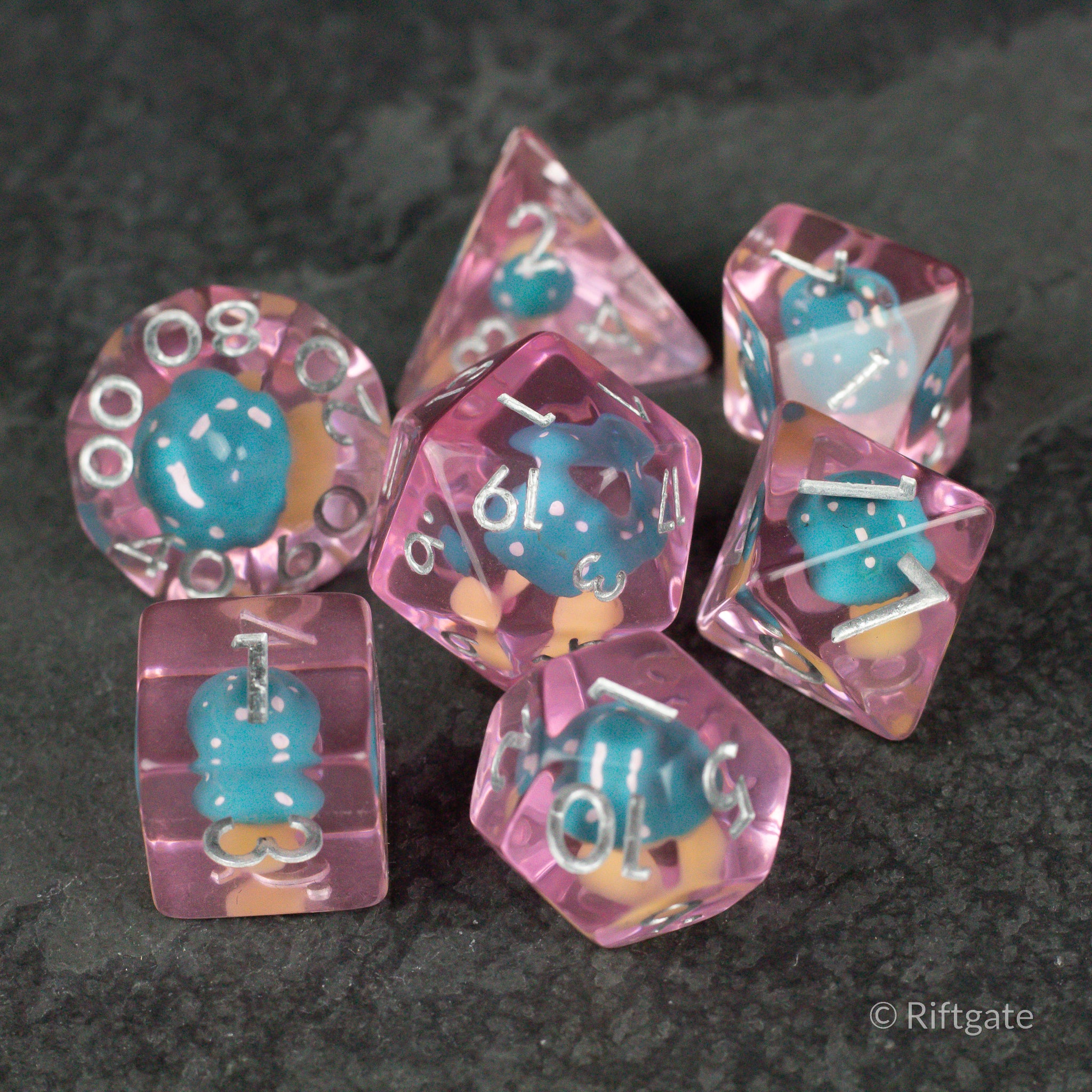 Blue + Pink Resin Mushroom Dice Set - Pink translucent resin dice set with blue mushroom inclusions and white numbering.