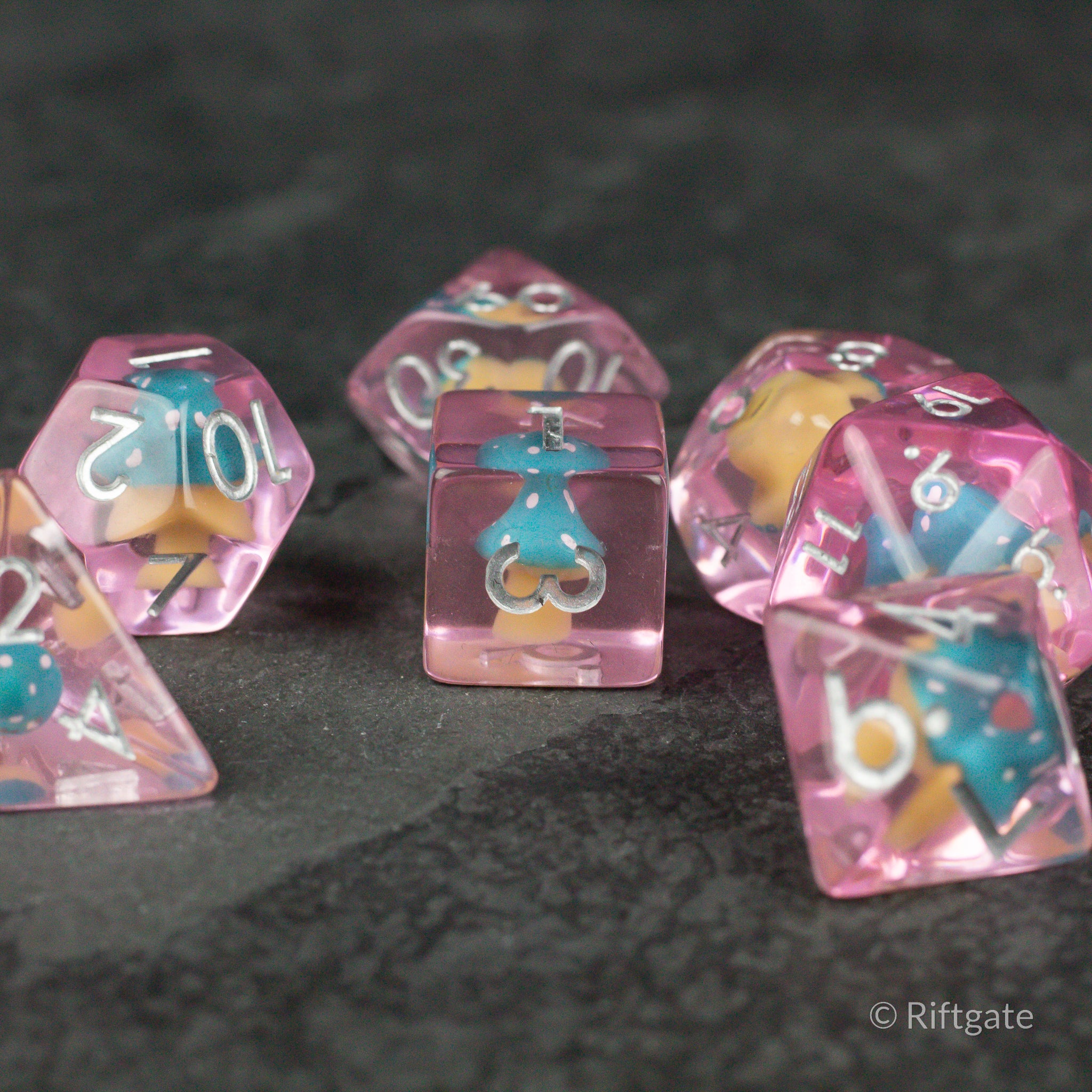 Blue + Pink Resin Mushroom Dice Set - Pink and blue resin dice set with mushroom inclusions, white numbering, and varied shapes.