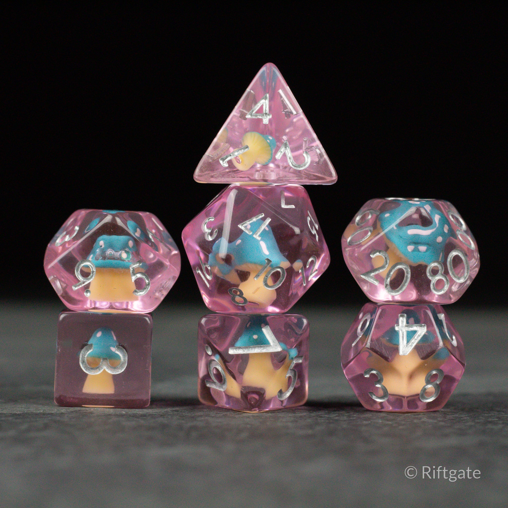 Blue + Pink Resin Mushroom Dice Set - Pink and blue resin dice set with embedded mushrooms and white numbering on black background.