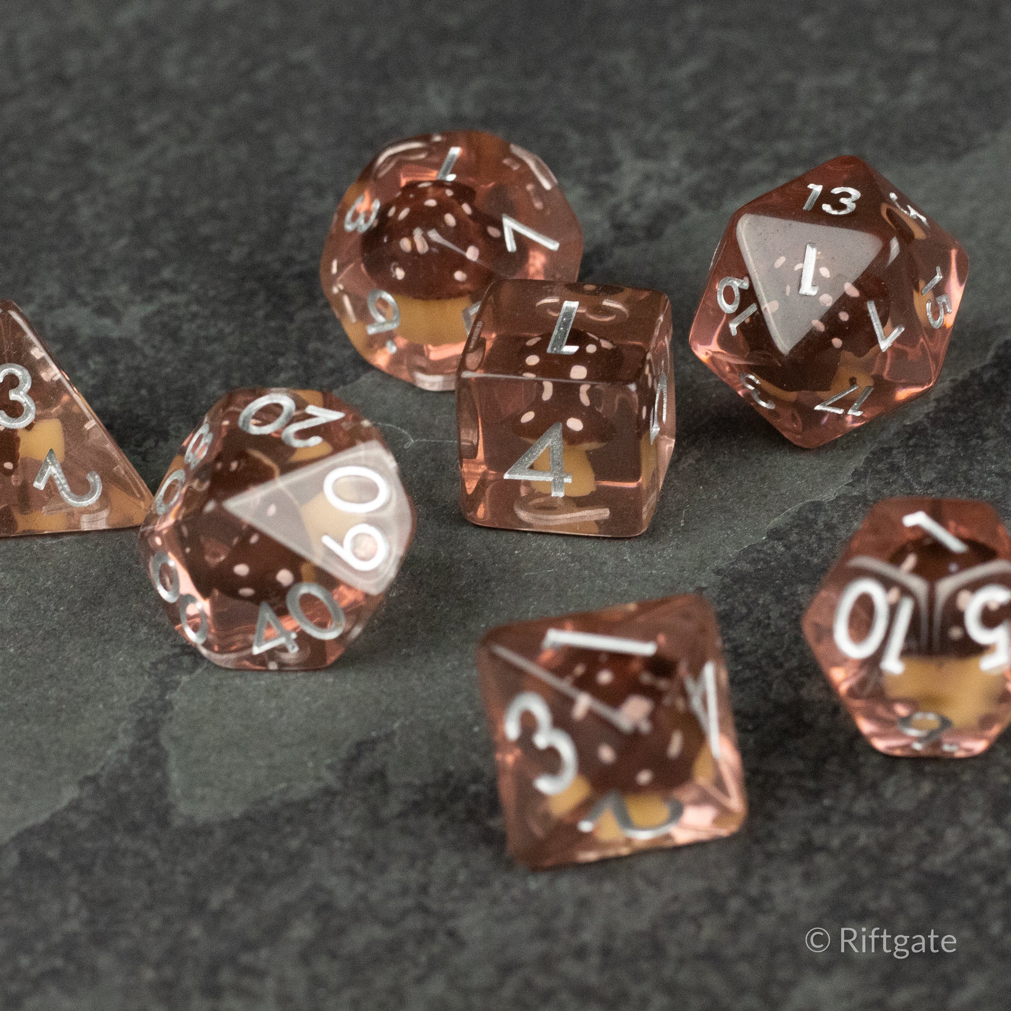 Coffee + Brown Resin Mushroom Dice Set - Brown translucent resin dice set with white numbering, featuring a mushroom-shaped inclusion inside each die on a dark.
