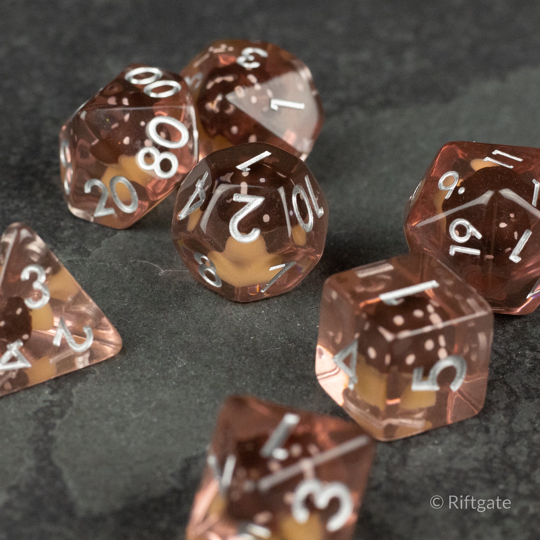 Coffee + Brown Resin Mushroom Dice Set - Set of seven transparent coffee and brown resin dice with white numbers, each featuring a small mushroom inclusion inside.