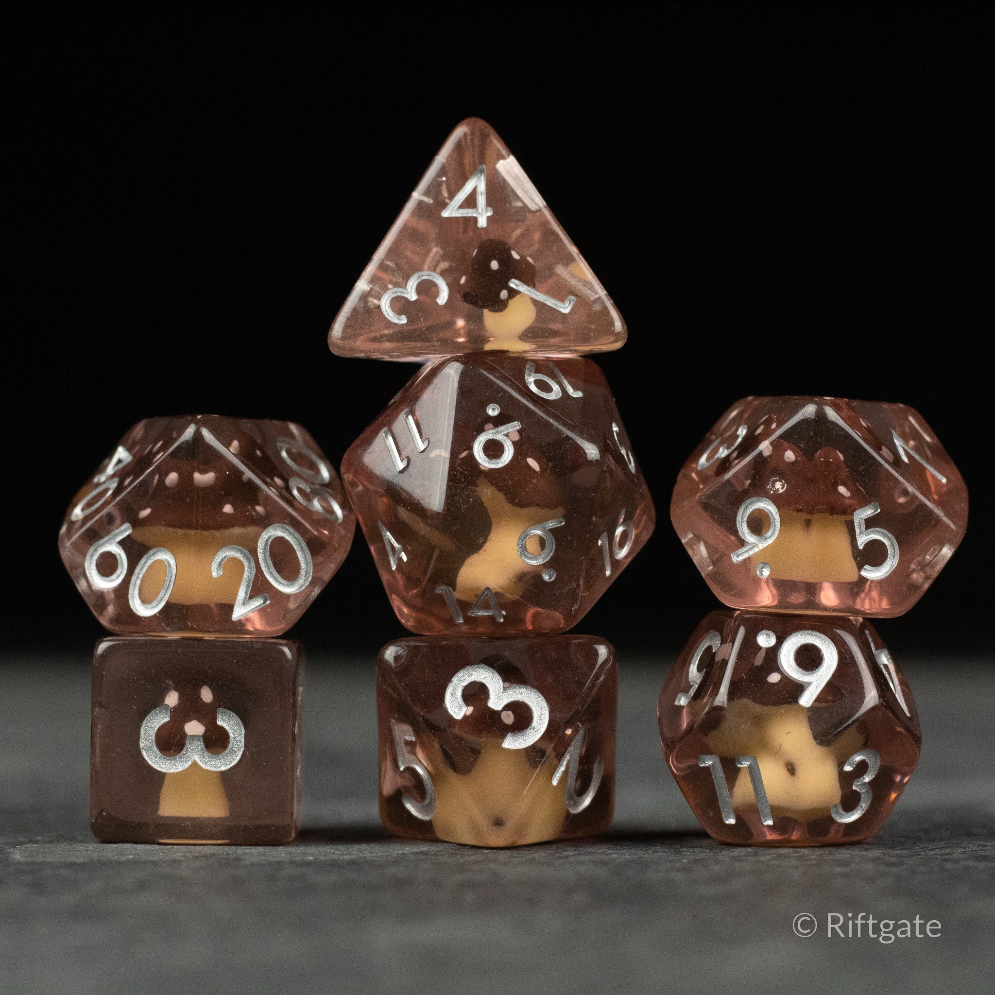 Coffee + Brown Resin Mushroom Dice Set - Set of seven brown translucent resin dice with coffee-colored mushroom-shaped inclusions and white numbering.
