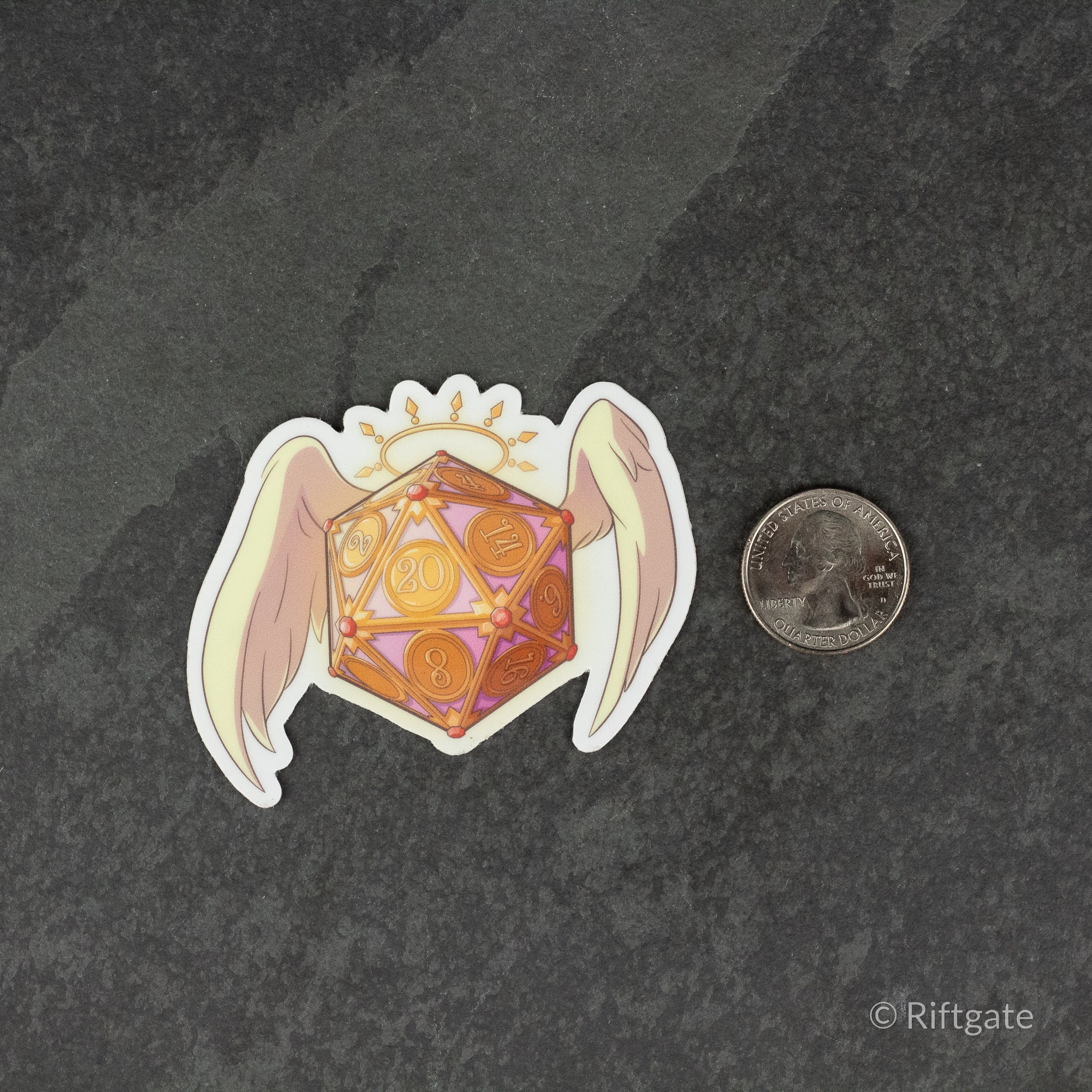 Angel D20 DnD Sticker - Orange and yellow 20-sided die with angel wings and a glowing halo sticker next to a quarter for size comparison.