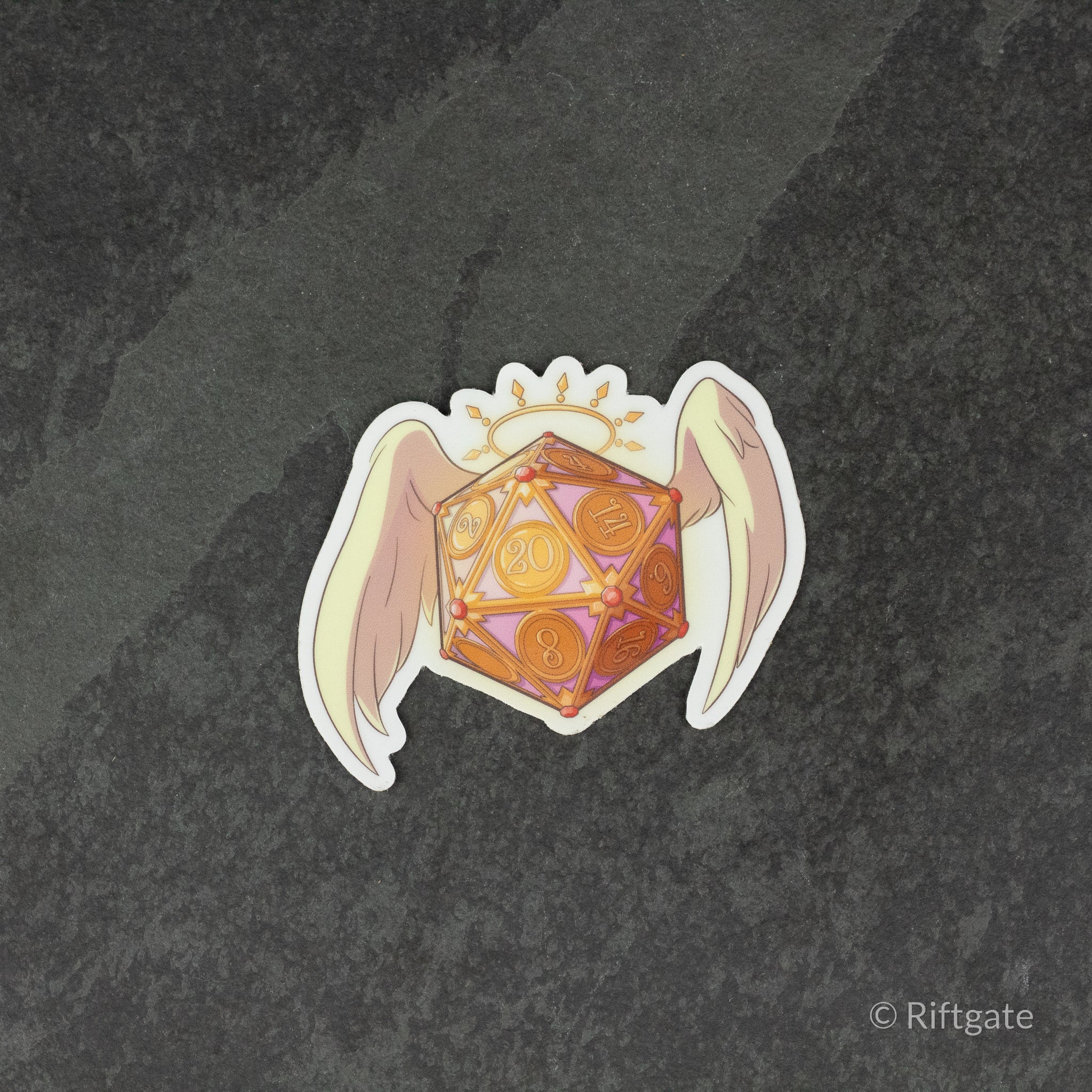 Angel D20 DnD Sticker - Orange and gold 20-sided die with angel wings and halo sticker on dark stone background.