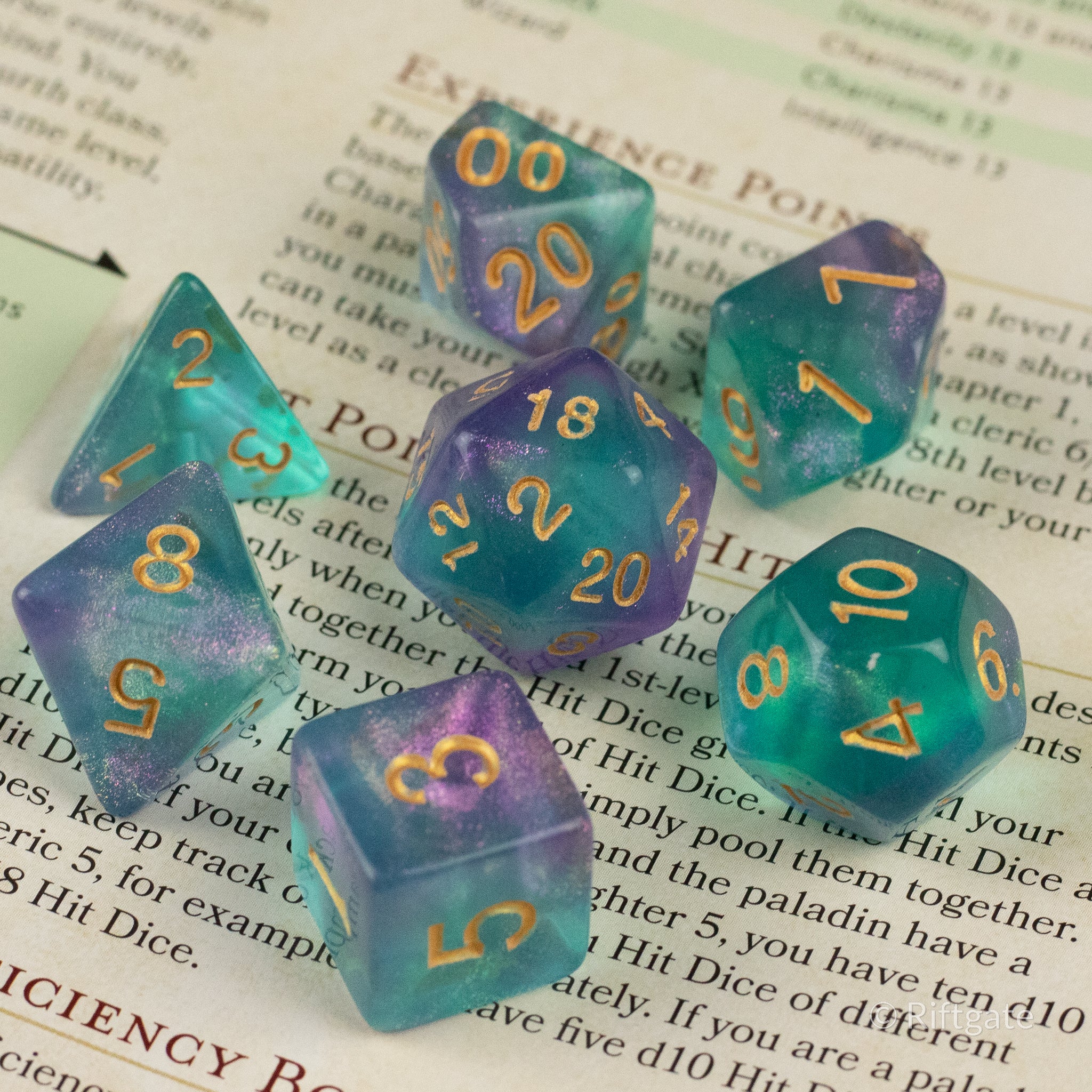 Faerie Glitter Dice Set - Set of seven translucent teal polyhedral dice with gold numbers and subtle glitter accents.