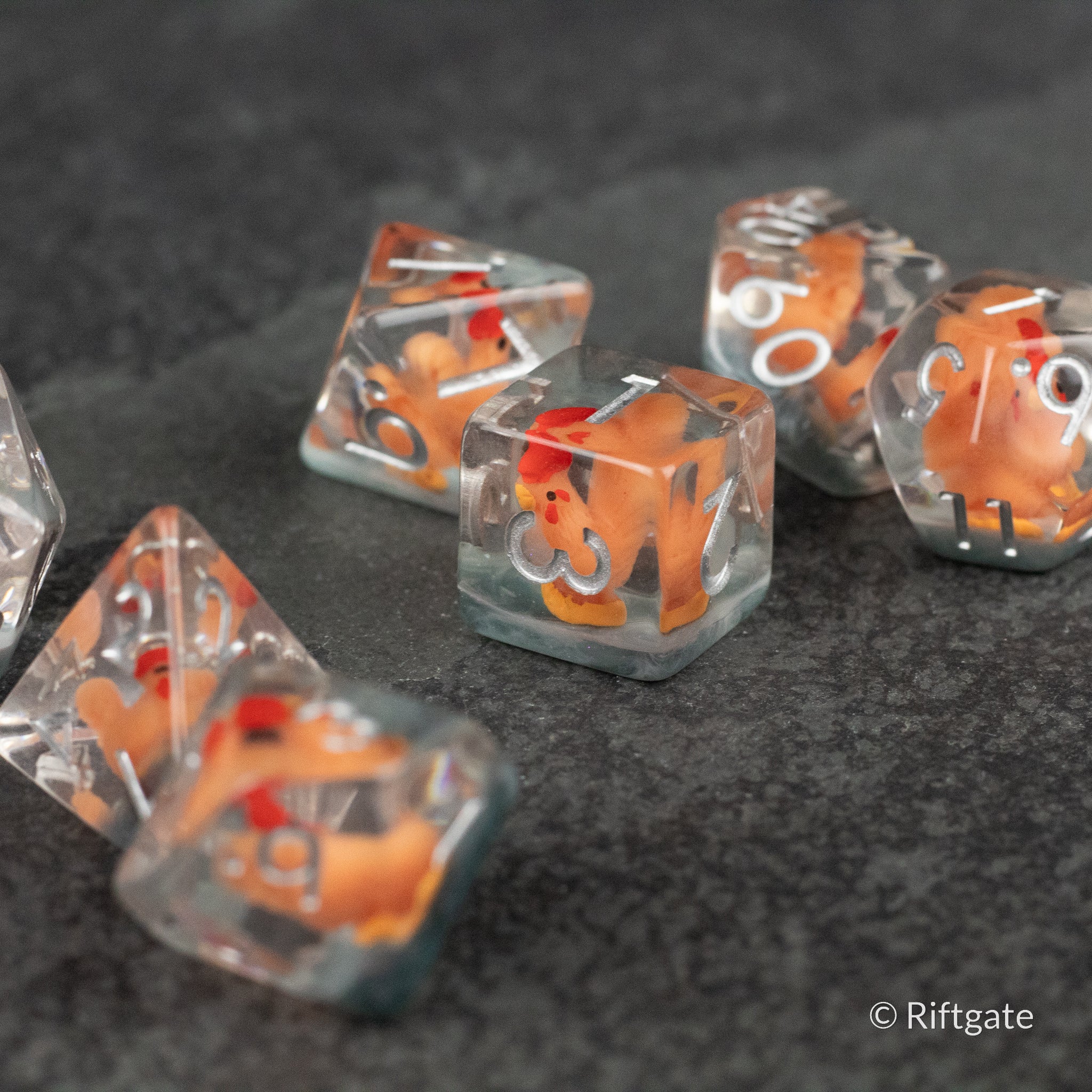 Chicken Dice Set - Clear plastic dice with bright orange chicken-shaped figures inside, white numbers on each die.
