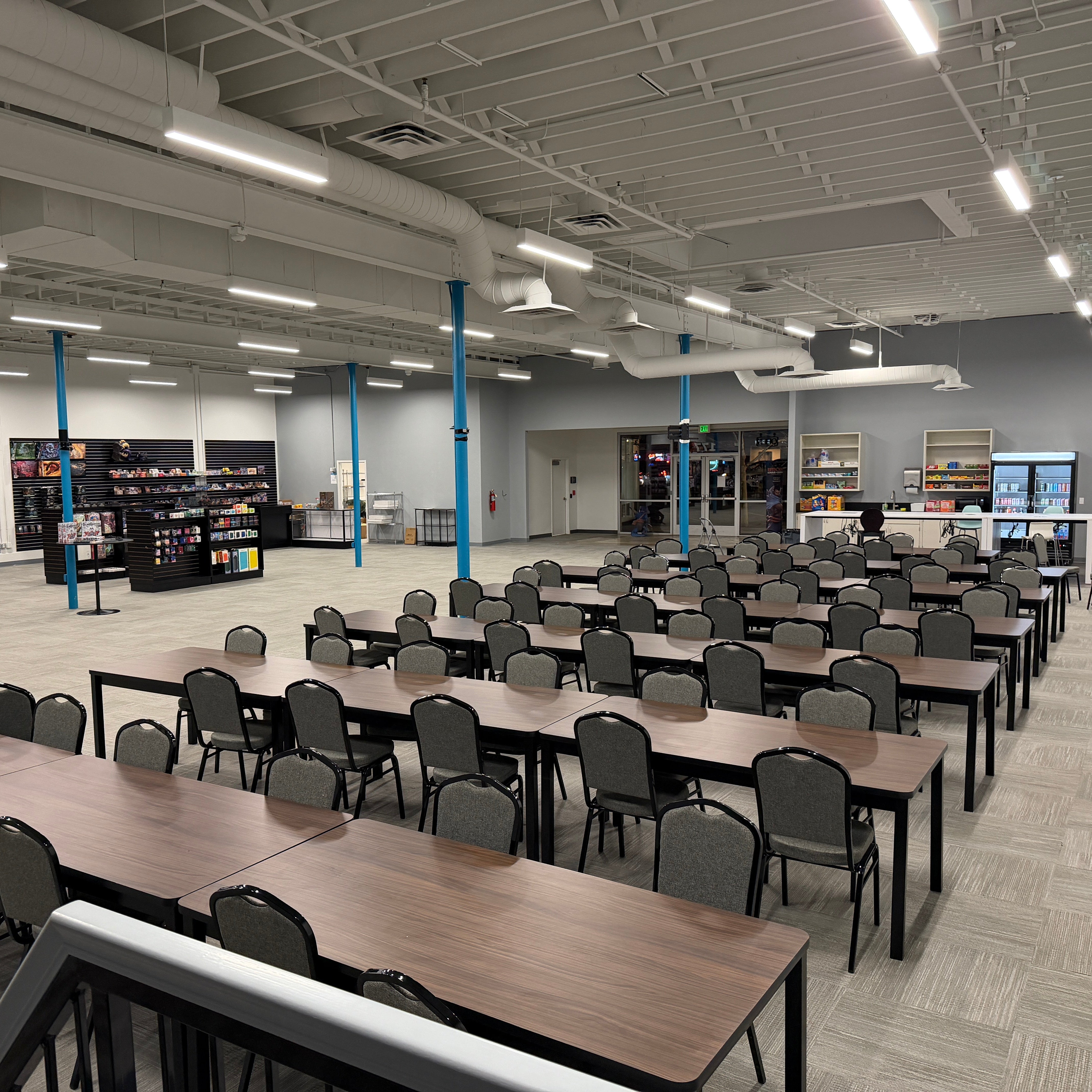 Large room with rows of tables and chairs.