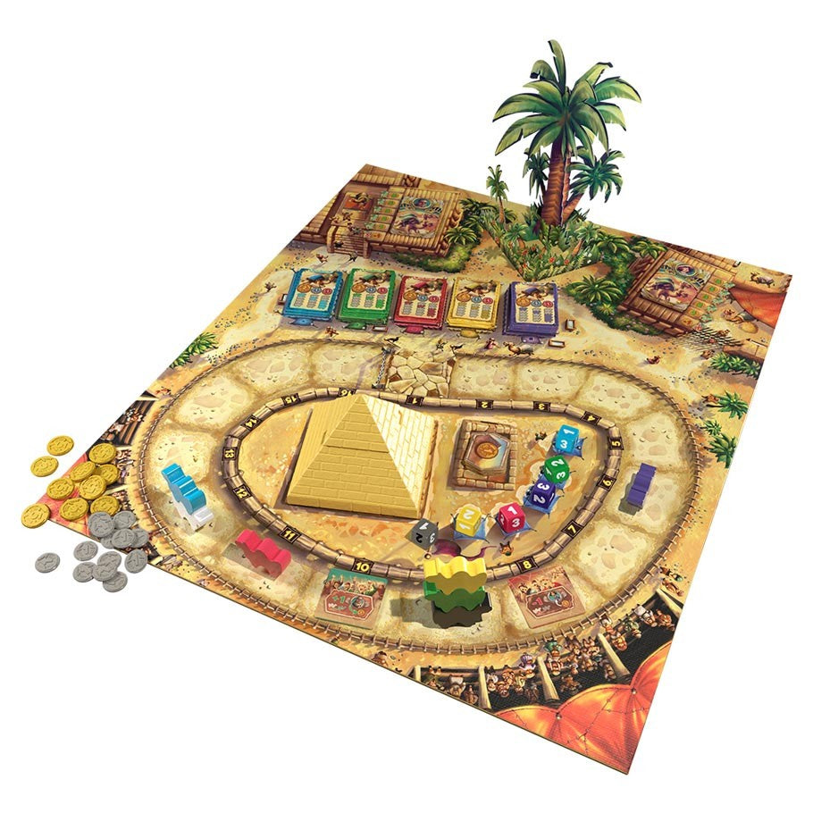 Camel Up - Board game featuring a desert race track with colorful camel tokens, pyramid centerpiece, palm tree, cards, and coins.