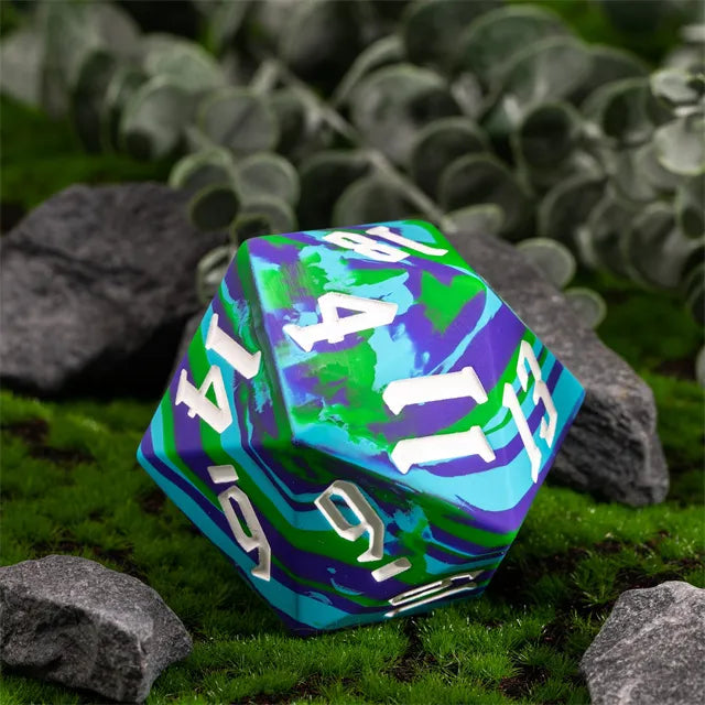 Giant Bouncy D20 - Blue & Green Stripes - Giant 20-sided dice with blue and green swirl stripes and white numbers resting on moss and rocks.