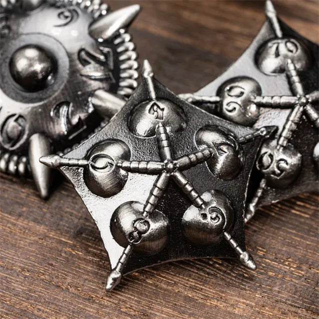 Dragon Theme Metal Dice - Metal dice set with intricate dragon-inspired design and spiked accents on dark wood surface.