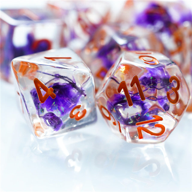 Purple Flower Dice Set - Type 2 - Clear polyhedral dice with embedded purple flowers and orange numbers, glossy finish.