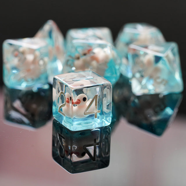 White Duck Dice Set - Translucent blue dice set with white duck figures inside each die, reflecting on black surface.